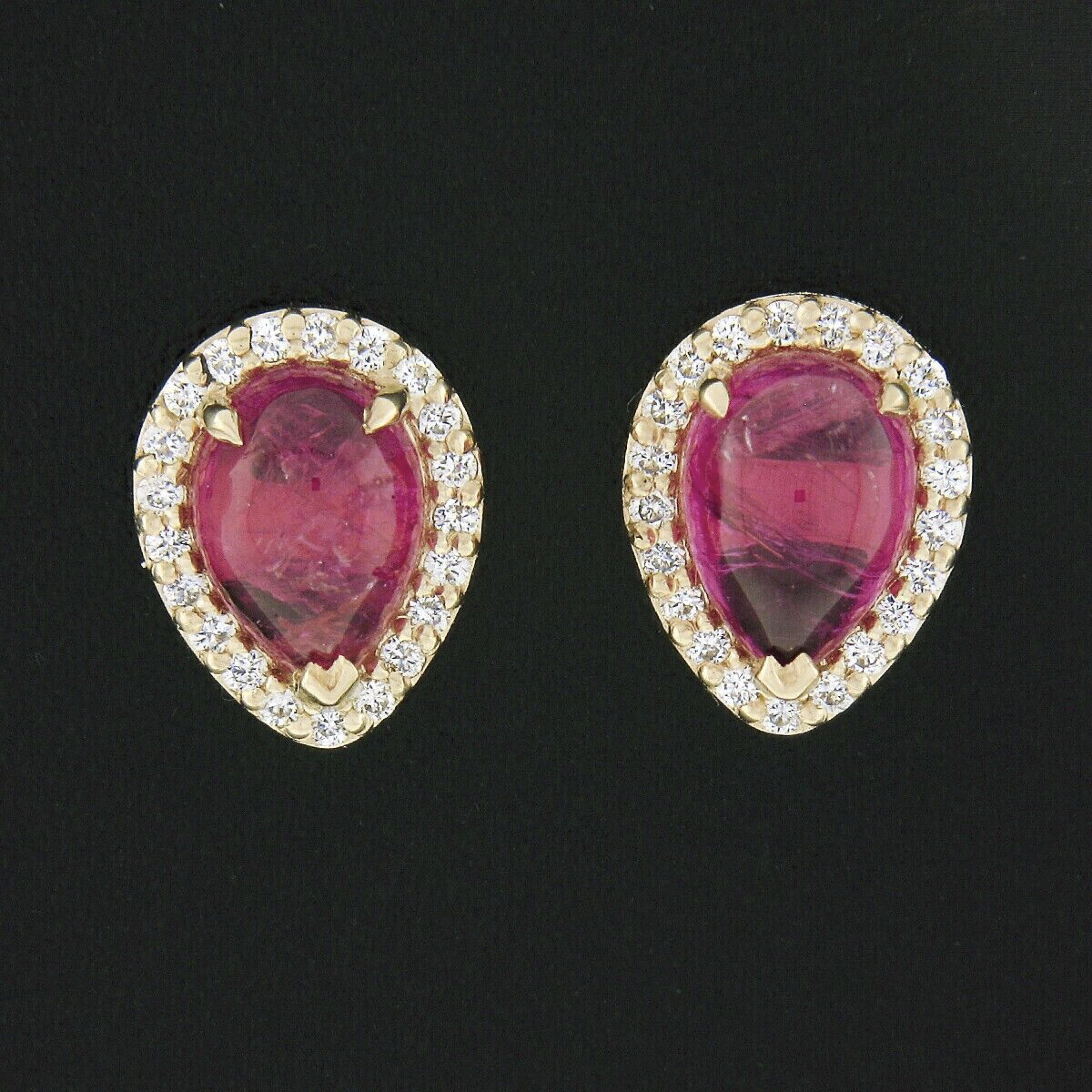 These beautiful custom made stud earrings are newly crafted in solid 14k yellow gold and feature a pair of stunning, pear cabochon cut rubies with a matching and super attractive pinkish-red color with no indications of heat treatment. The fine