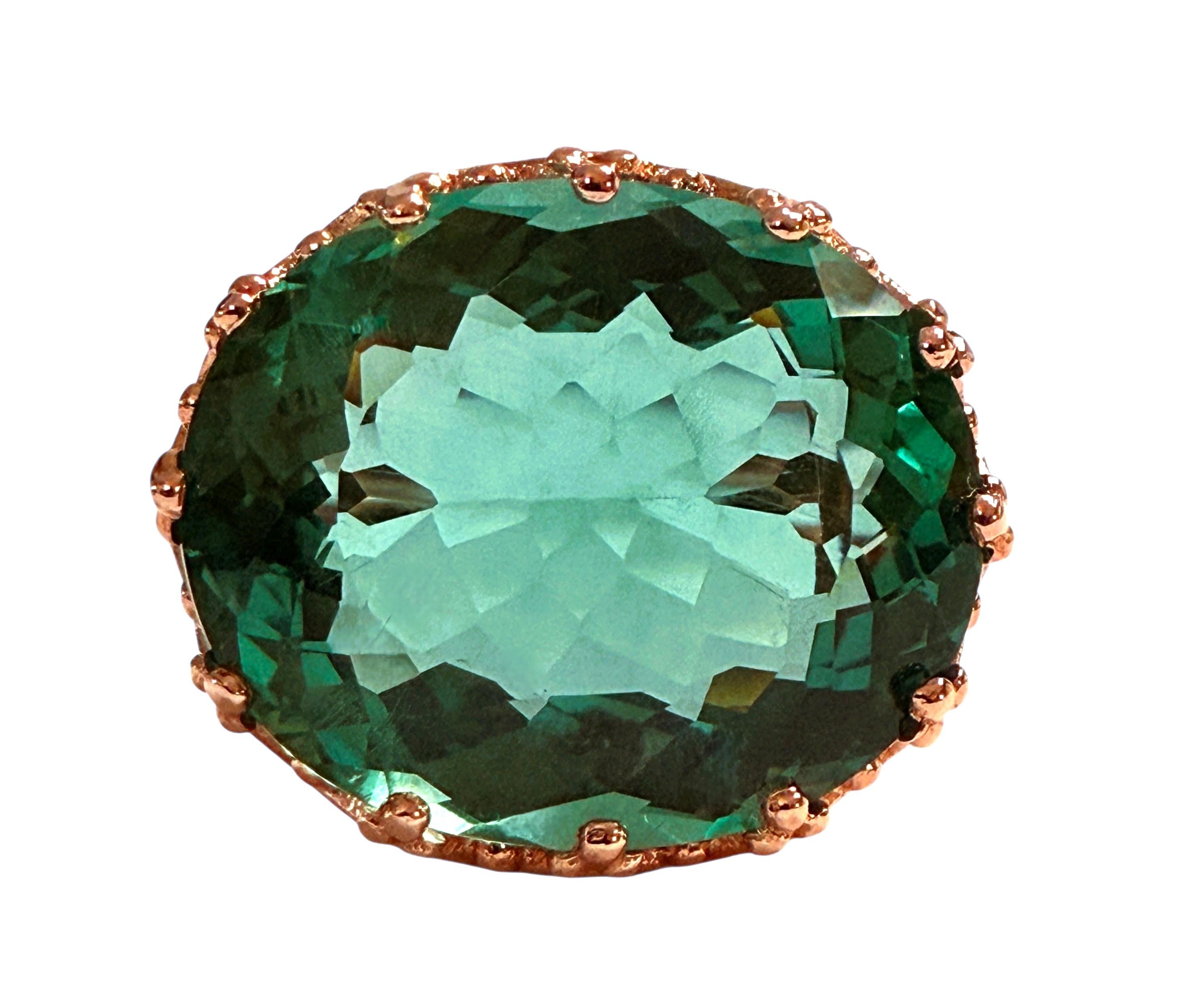 La pietra proviene dall'Africa ed è semplicemente squisita. La pietra è una tormalina verde acqua di 15,10 carati.  La pietra, di forma ovale, misura 18 x 15 mm ed è incastonata in una splendida corona di diamanti placcata in oro rosa in argento