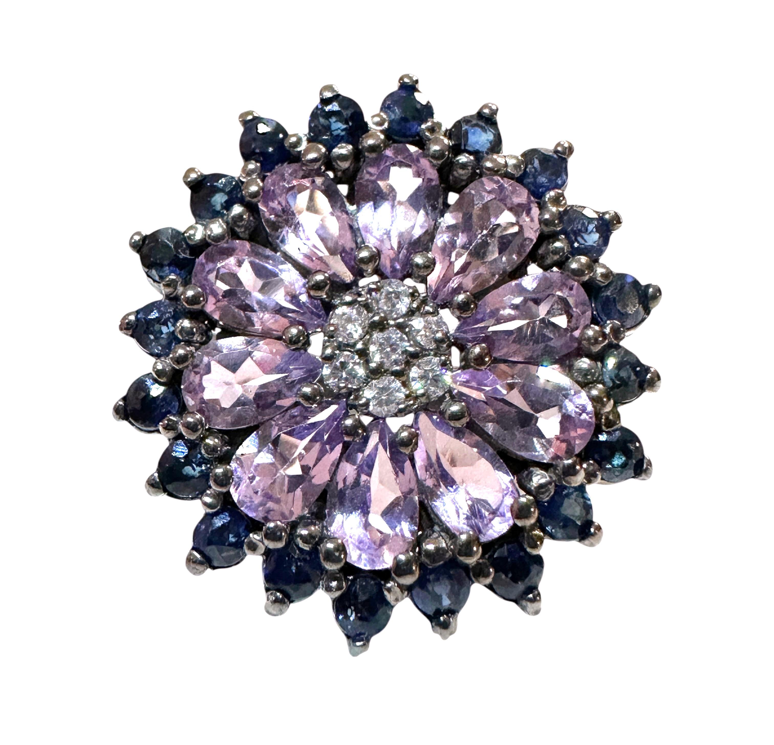 This is just a beautiful ring.  The ring has 10 pear cut Amethyst stones measuring approximately 4 x 2 mm.  They total 1.7 carats.  They are surrounded by diamond cut Blue Sapphires and in the middle are 7 diamond cut white sapphires.  The color
