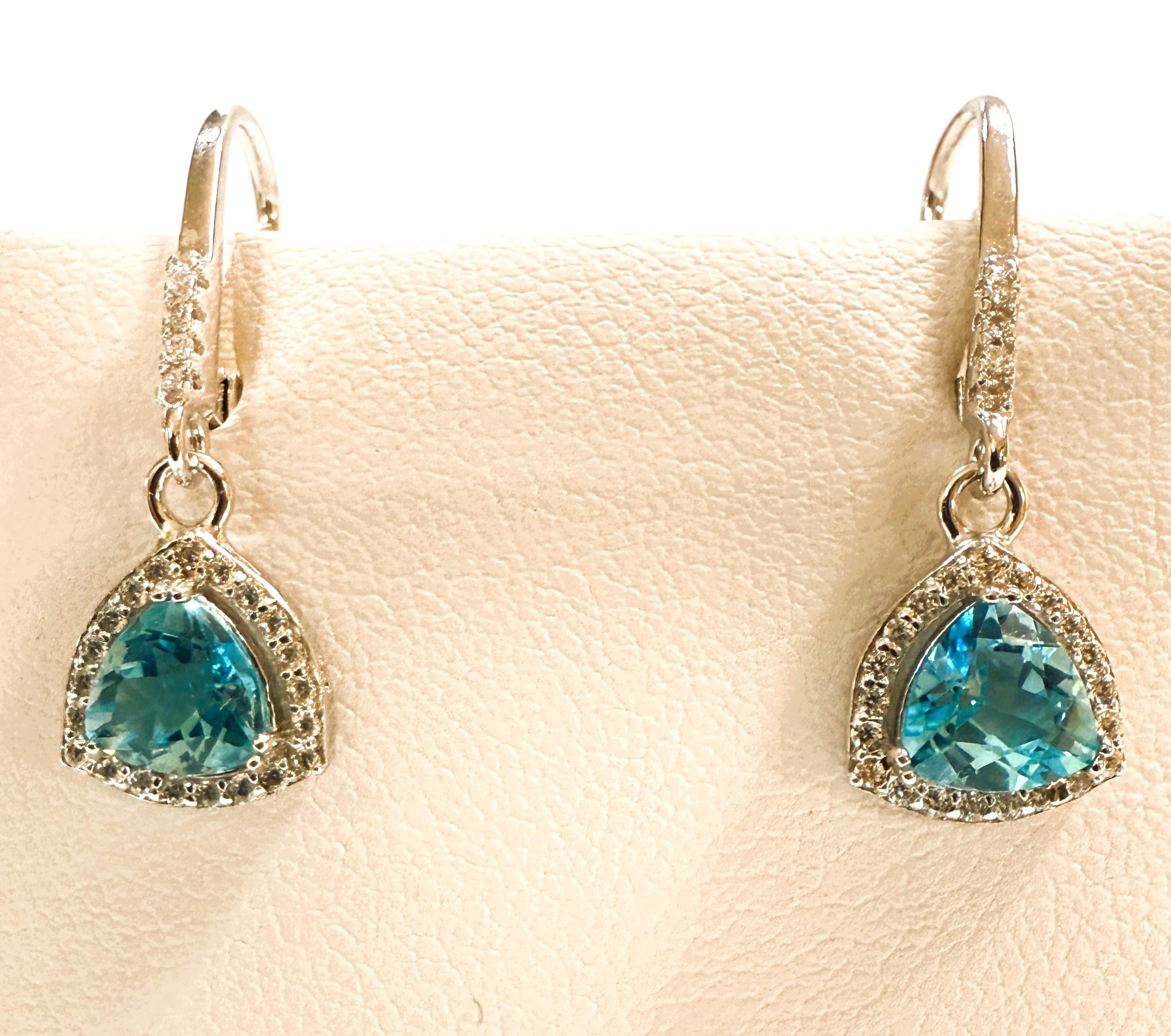 Diese zierlichen Ohrringe sind einfach wunderschön!  Die Steine sind Trillion geschnitten Blue Topaz Stones und jeder ist .91 Karat, insgesamt 1,82 Karat für beide Ohrringe.  Jeder Stein misst 6,5 x 6,5 mm.  Sie sind von weißen Saphiren im