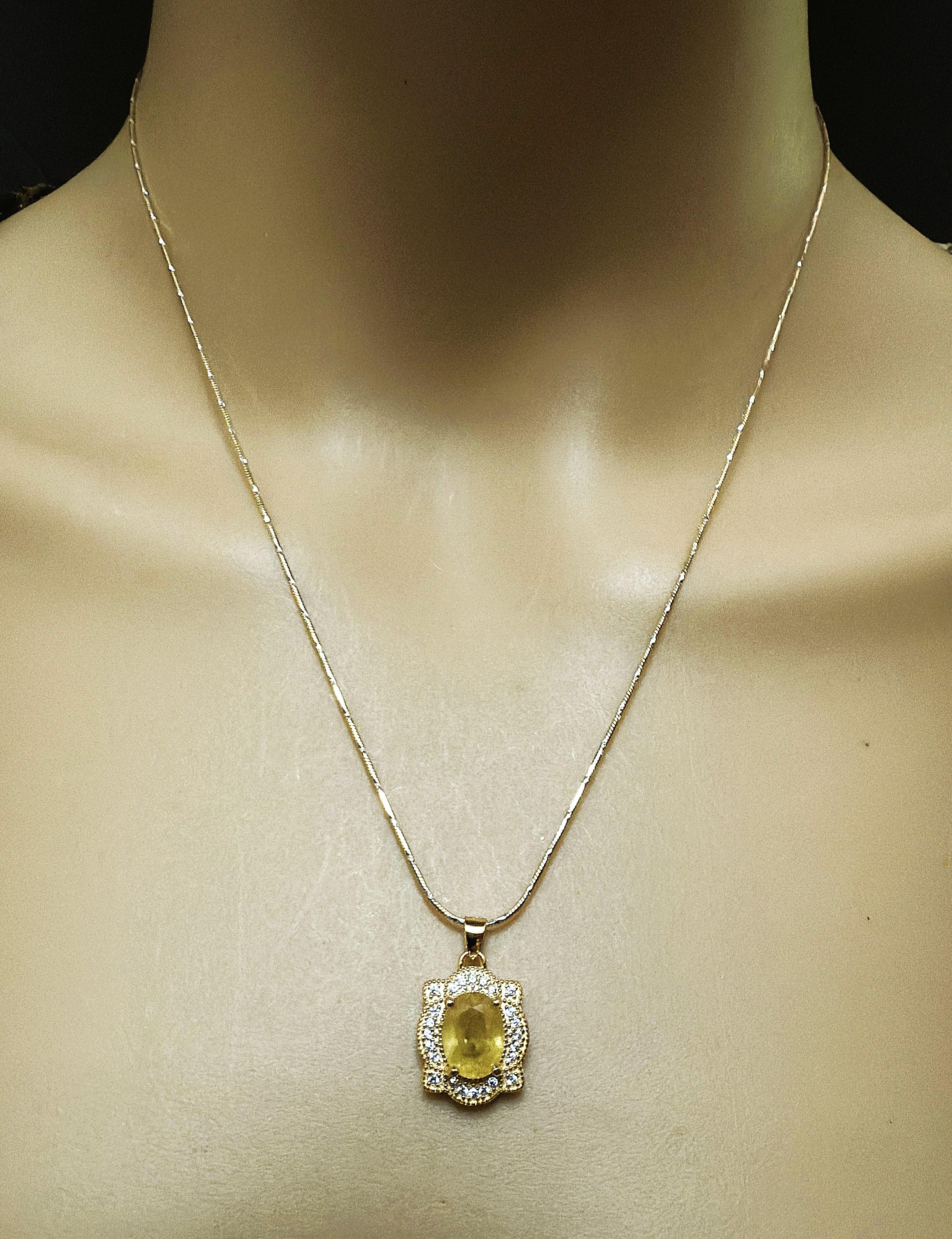 Dies ist eine wunderschöne Halskette.  Man sieht sie nicht oft in dieser Farbe.   Der Stein ist ein natürlicher gelber Topas im Ovalschliff und hat 1,86 Karat.  Er ist 9 x 7 mm groß und wird von weißen Saphiren mit Diamantschliff umgeben.  Sie sind
