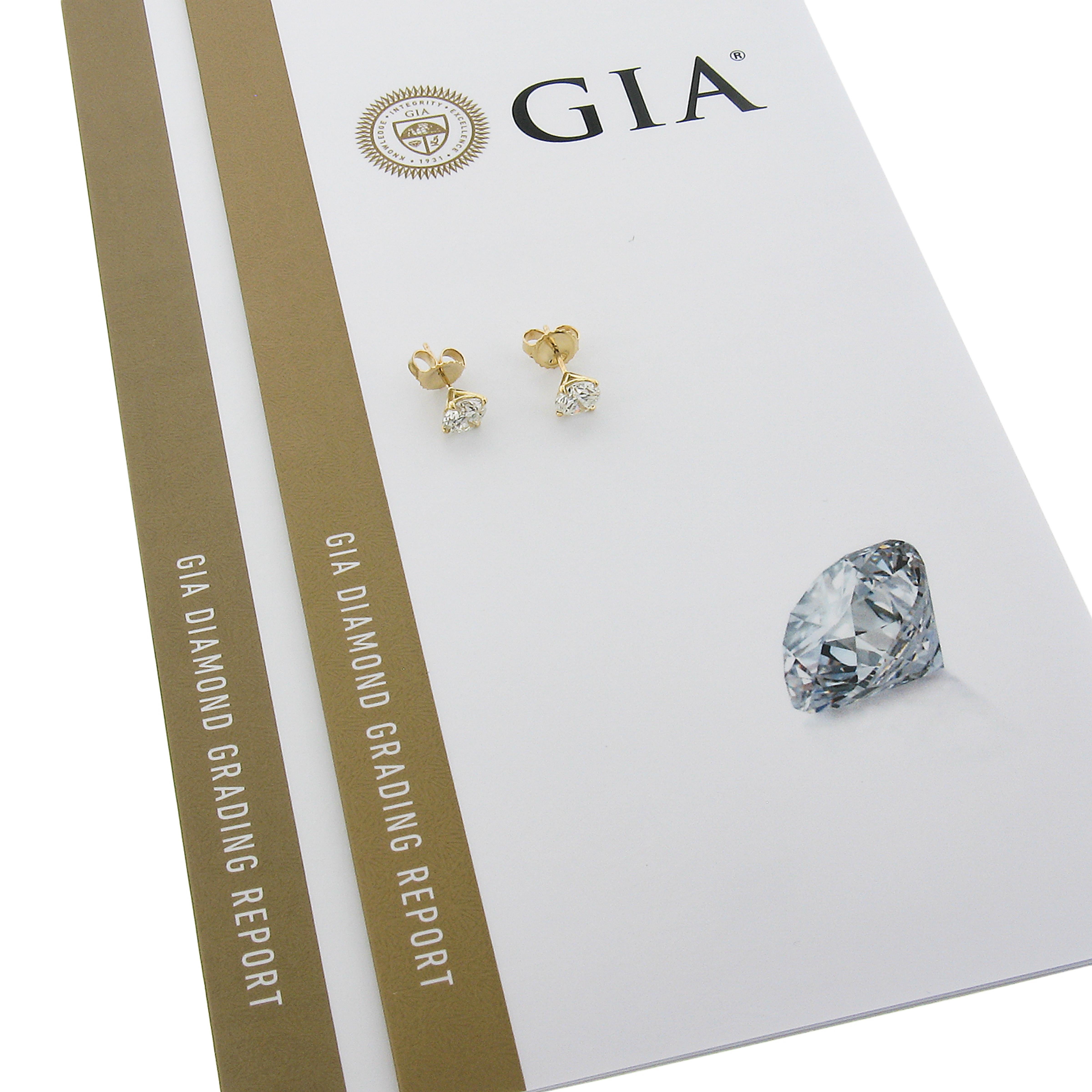 This classic and super elegant pair of diamond stud earrings is crafted in solid 18k yellow gold and features two brilliant and fiery, GIA certified, round brilliant cut diamonds that are neatly claw prong set in sturdy martini style settings. These