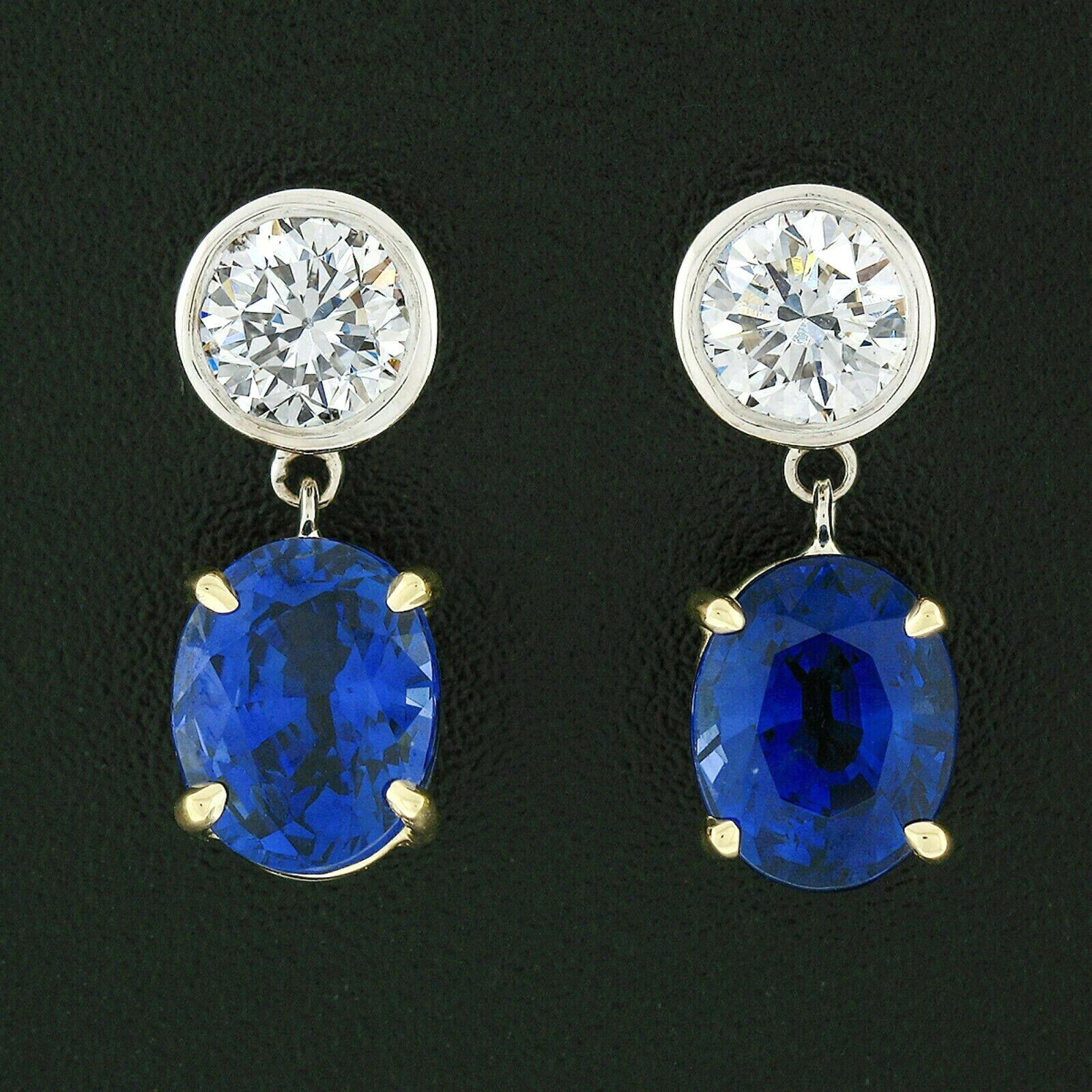 These magnificent, brand new, custom made earrings were crafted in solid 18k gold and feature a matching pair of GIA certified oval brilliant cut blue sapphires prong set in sturdy yellow gold baskets. The sapphire stones are a breathtaking, SUPER