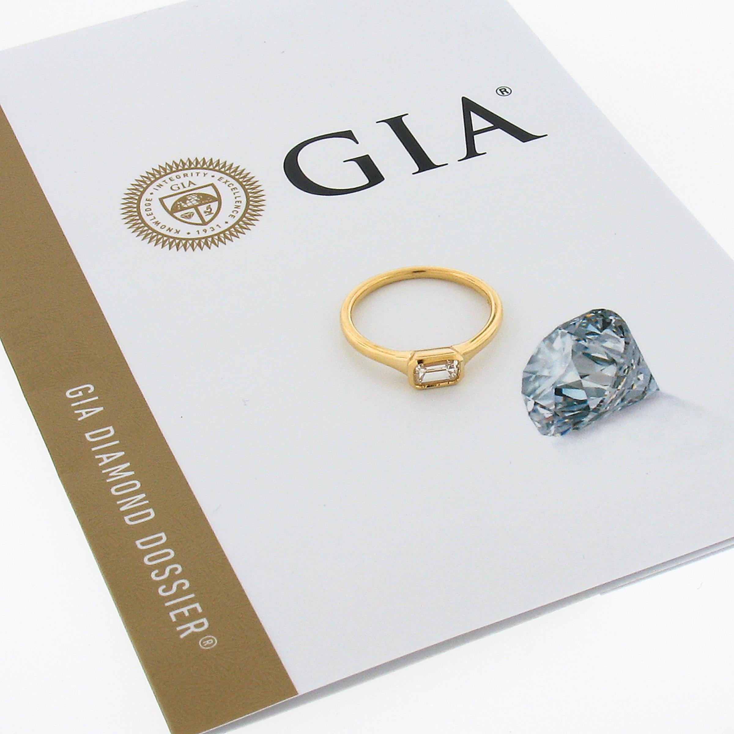 Nous avons ici une bague solitaire en diamant simple, mais absolument magnifique, qui a été récemment fabriquée en or jaune massif 18k. Le solitaire certifié par le GIA a une taille émeraude et est soigneusement serti latéralement au centre de la