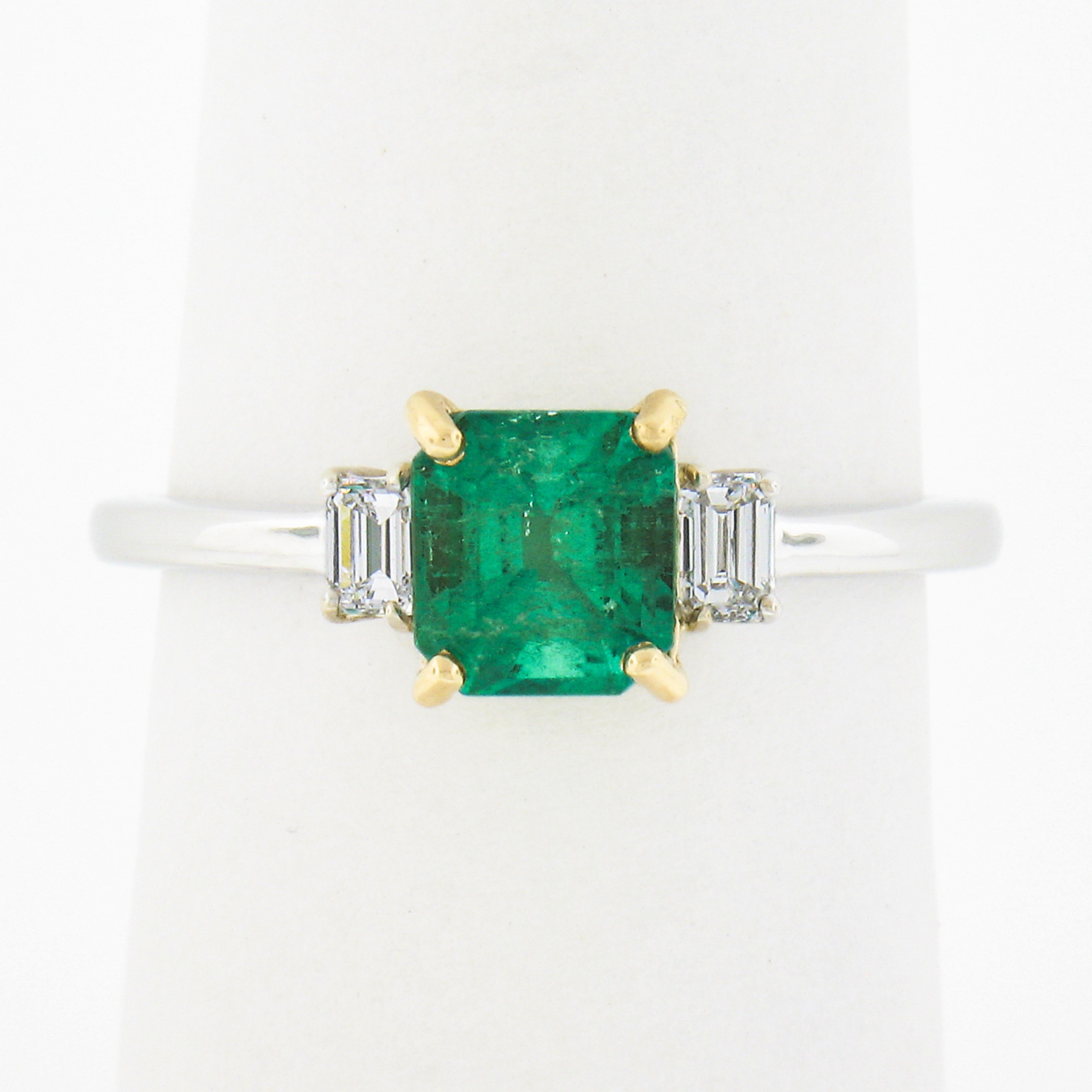 Here we have a magnificent emerald and diamond ring that is newly crafted in solid 18k white gold with a yellow gold center that features a gorgeous natural Colombian emerald stone. The solitaire displays a vibrant and truly incredible happy green
