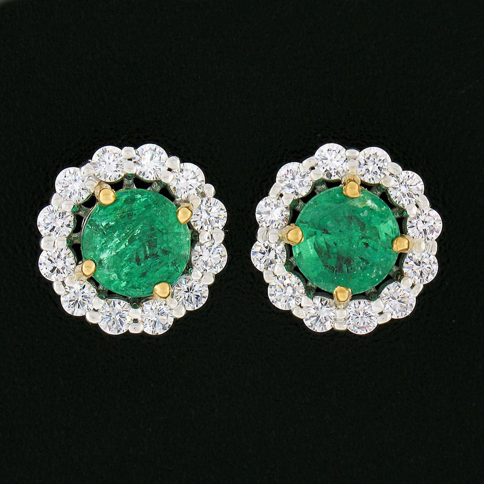 This gorgeous pair of custom made emerald and diamond halo stud earrings is newly crafted in solid 18k white gold with a yellow gold center. Each earring features a stunning natural emerald stone neatly prong set at its center having a rare round