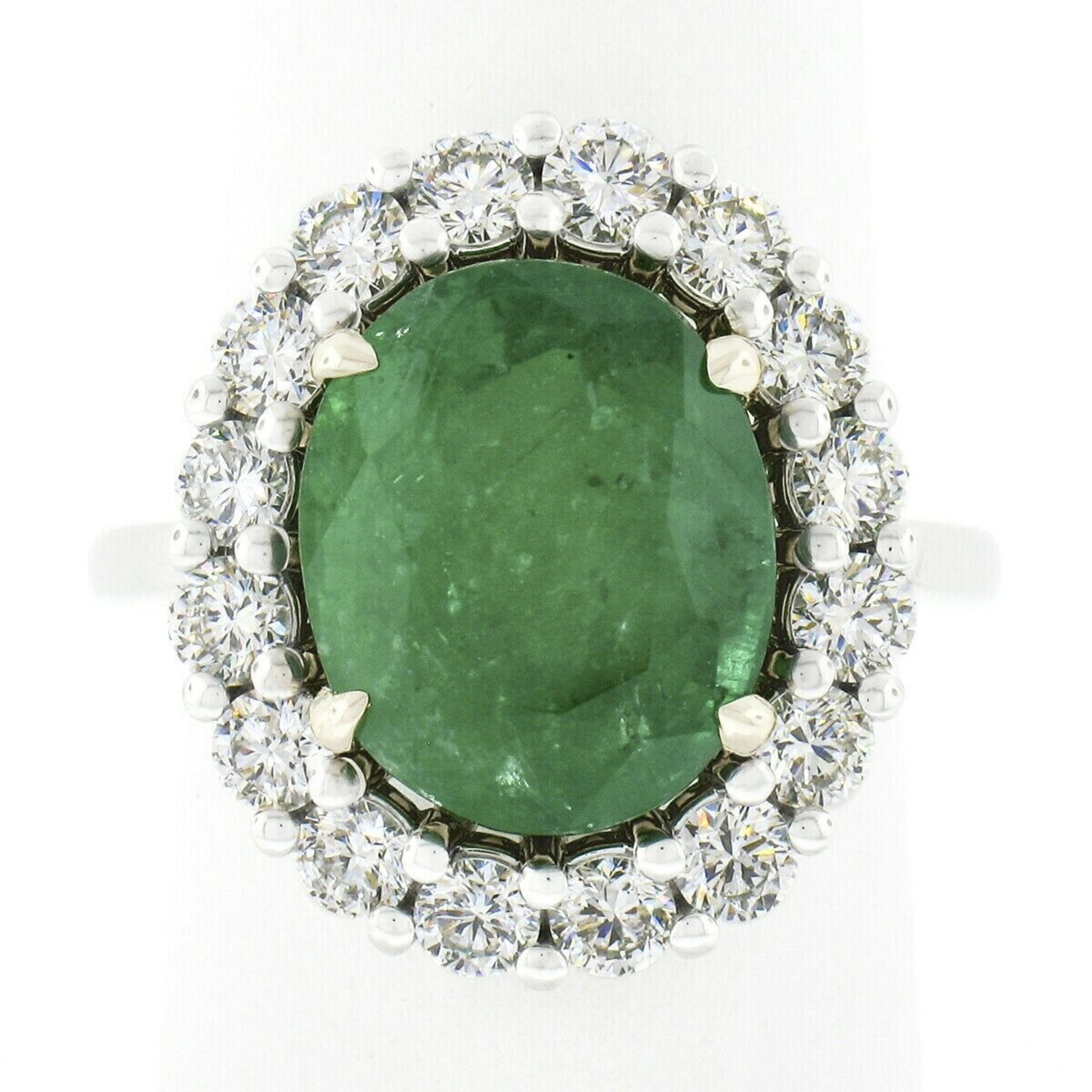 You are looking at a truly breathtaking emerald and diamond cocktail ring newly crafted in solid 18k white gold with a solid 18k yellow gold center basket that features a large, GIA certified, emerald stone. The oval cut emerald is neatly prong set
