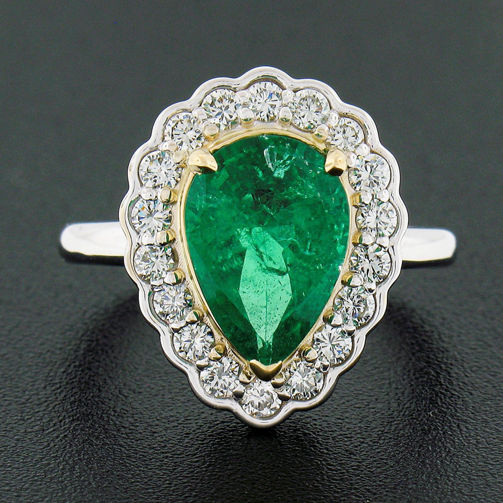 This absolutely magnificent emerald and diamond custom made ring is newly crafted in solid 18k white gold and features an incredible 3.19 carat pear cut emerald neatly prong set at its center in a solid 18k yellow gold basket. This natural emerald