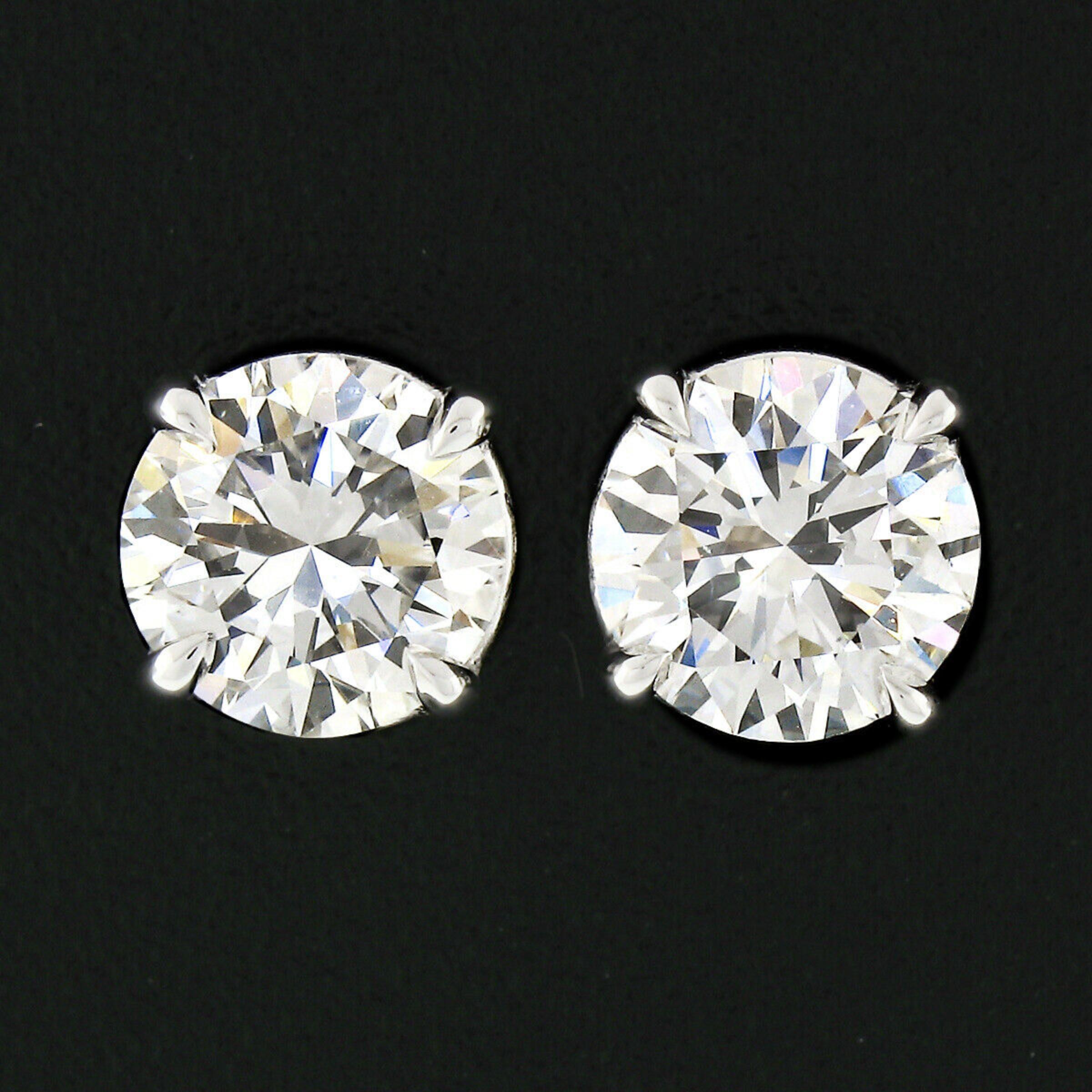 This magnificent pair of diamond stud earrings is newly crafted in solid 18k white gold and features two VERY fine quality round brilliant cut diamonds with colorless F & G color and solidly loupe-clean with VVS1 & VS1 clarity. They are both