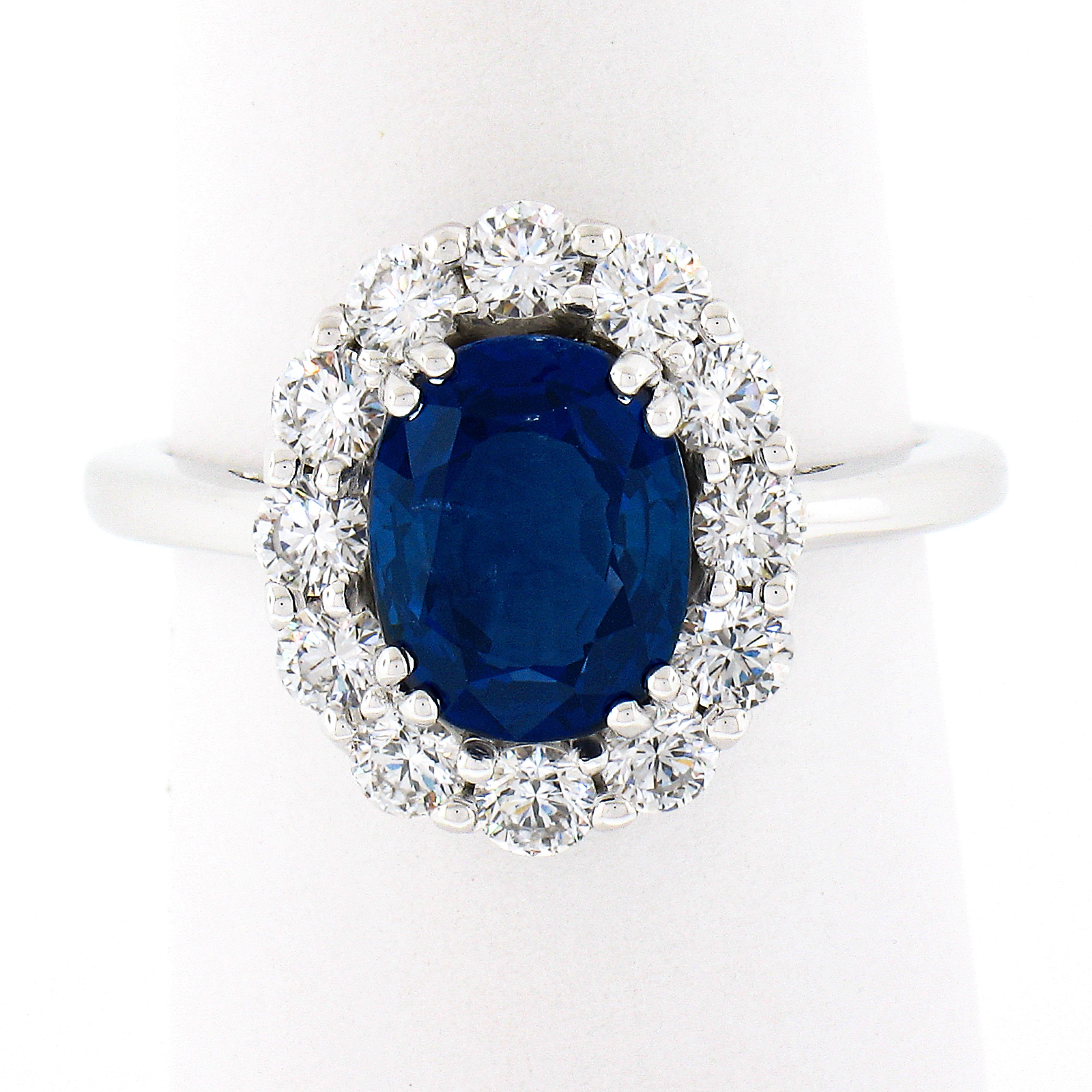 This absolutely magnificent and very well made sapphire and diamond ring is newly crafted in solid 18k white gold and features an incredible, 2.56 carat, old sapphire stone neatly dual prong set at the center of a super fiery diamond halo. This