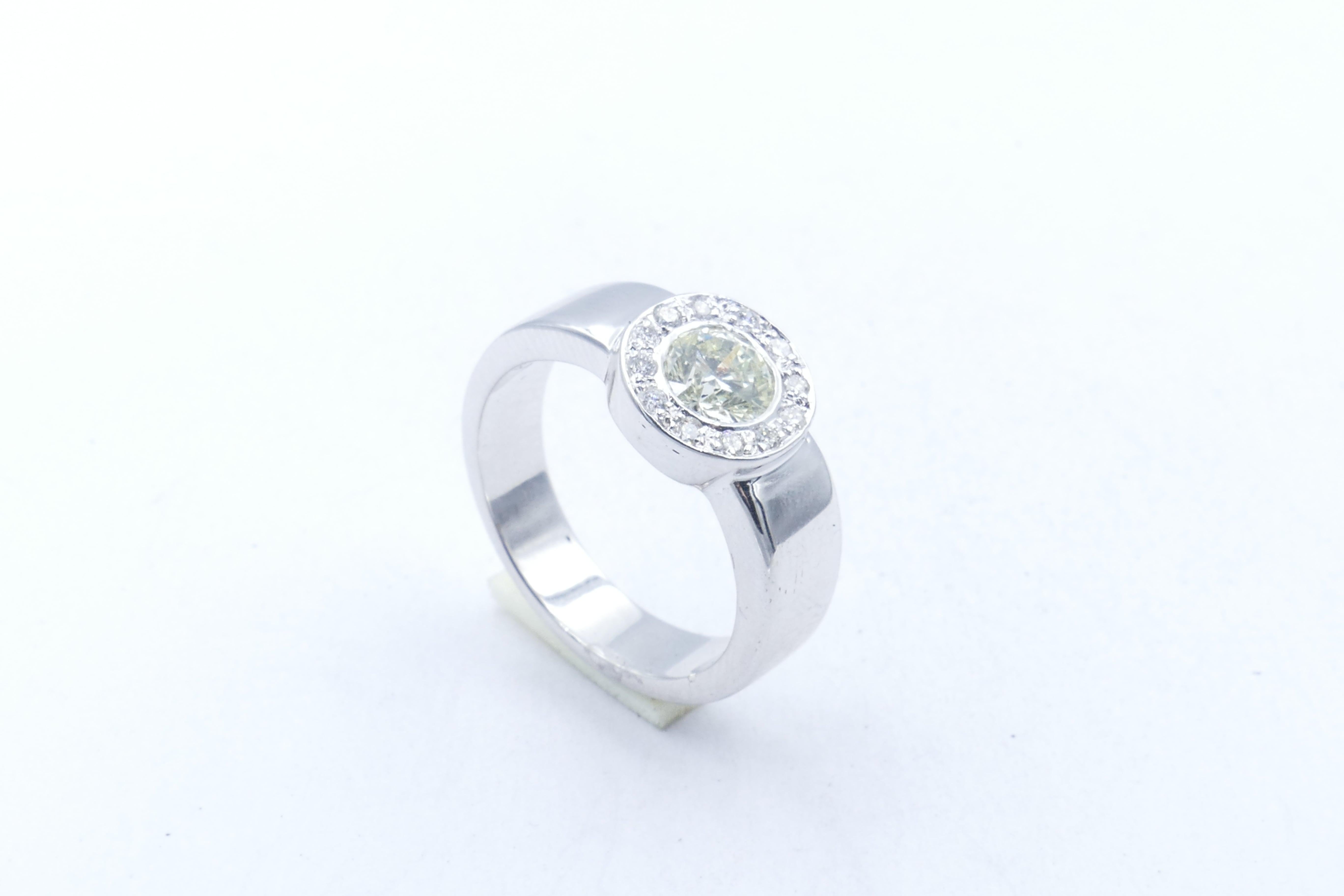 Purchased in Dublin, this One  X 0.84K round brilliant cut Diamond, colour H, Clarity SI1 is bezel set and centres 12 further round brilliant cut Diamonds, colour G/H, clarity SI1-SI2, bead set.
The setting is a very solid but so attractive Halo