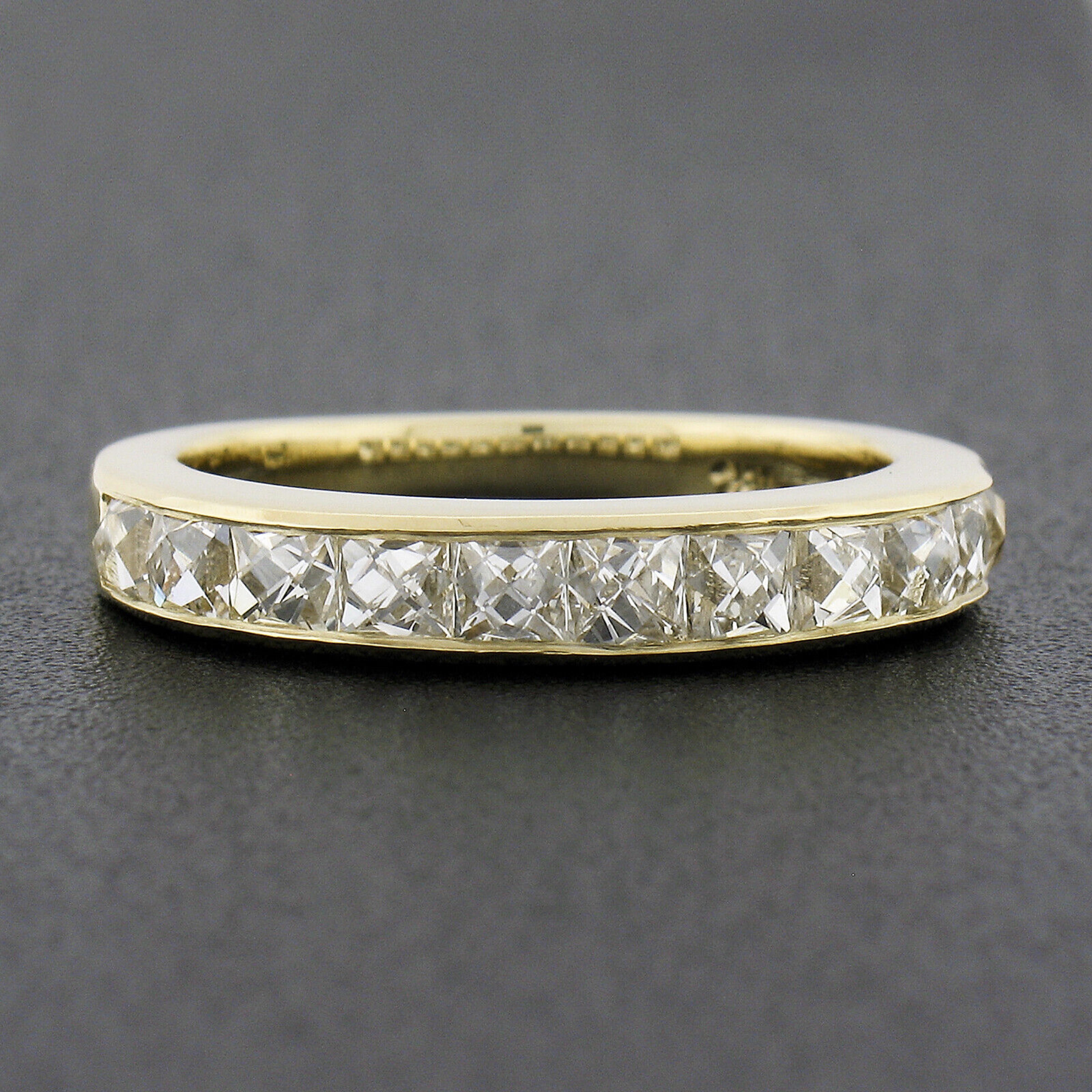 Here we have a brand new diamond band ring that is crafted in solid 18k yellow gold and features 11, very fine quality, square French cut diamonds neatly channel set across its top. These stunning and super lively diamonds total exactly 2.25 carats