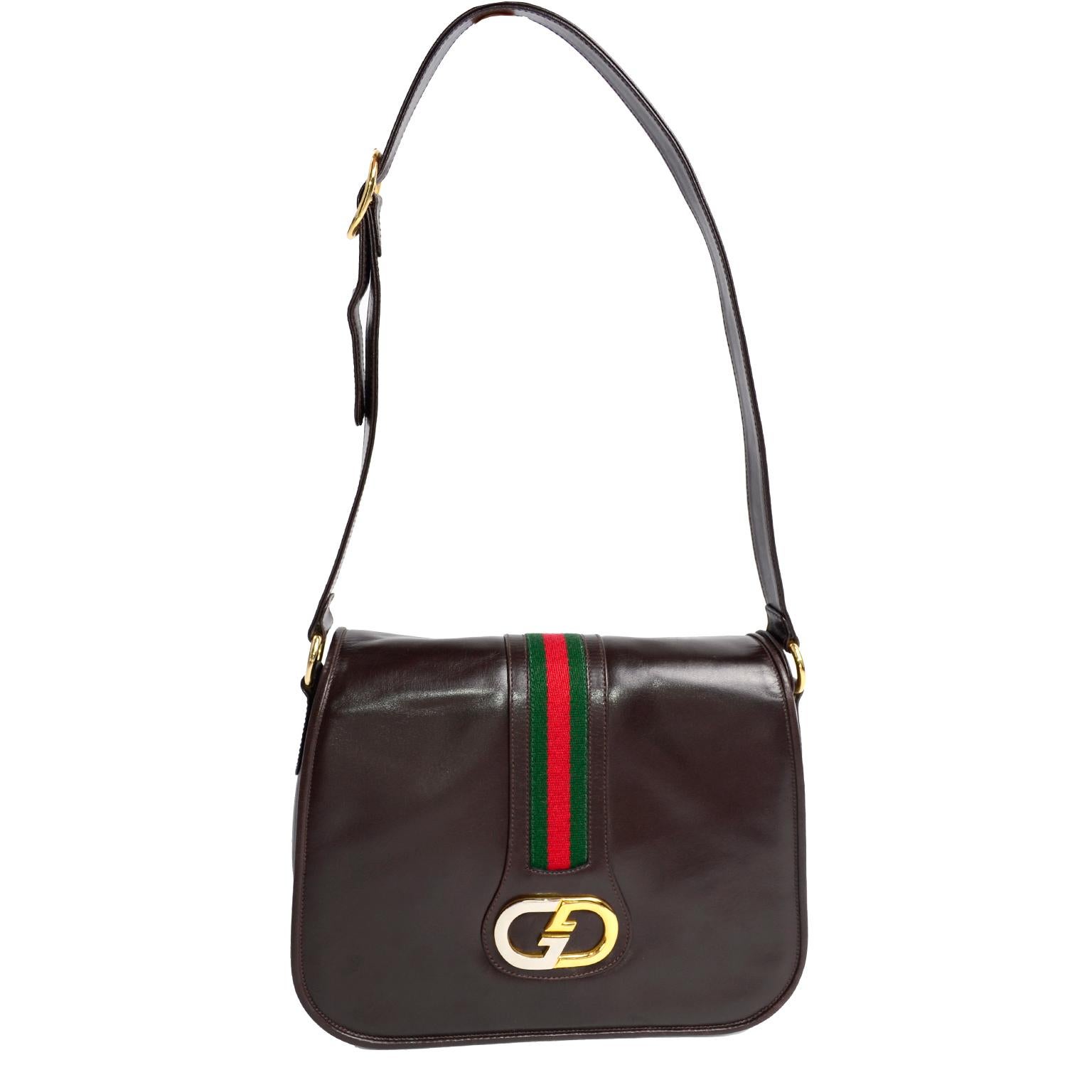 This is a classic vintage Gucci brown leather bag purchased at Joseph Magnin in 1979. This wonderful handbag still has its original tags attached and is accented with the iconic Gucci monogram buckle in silver and gold, and  Italian red and green