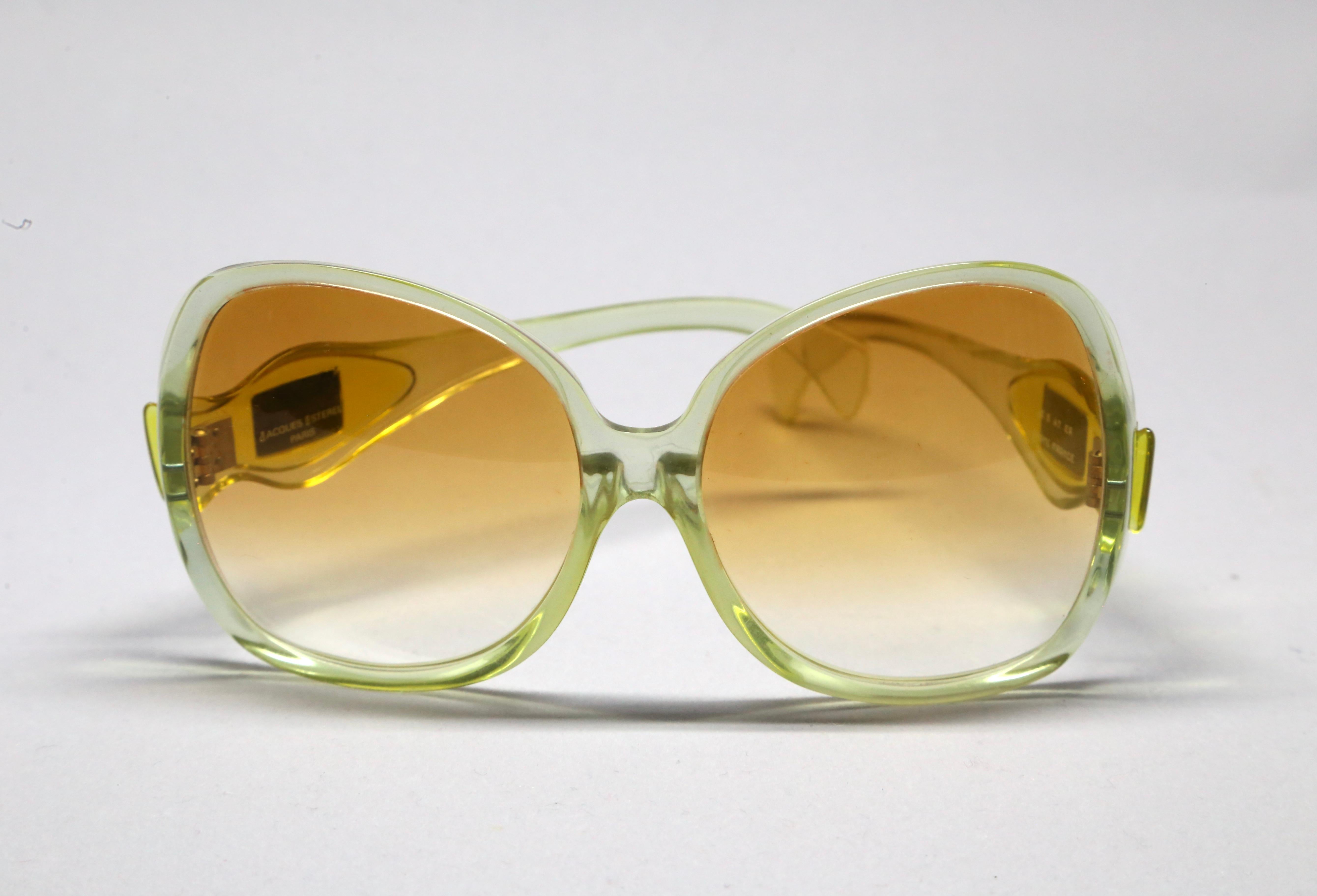 Oversized transparent yellow acetate sunglasses with brown gradient lenses from Jacques Esterel dating to the 1970's.  JE logos at temples. Approximate measurements: 
• frame height: 67mm
• temple length (from the hinge and including ear bend):