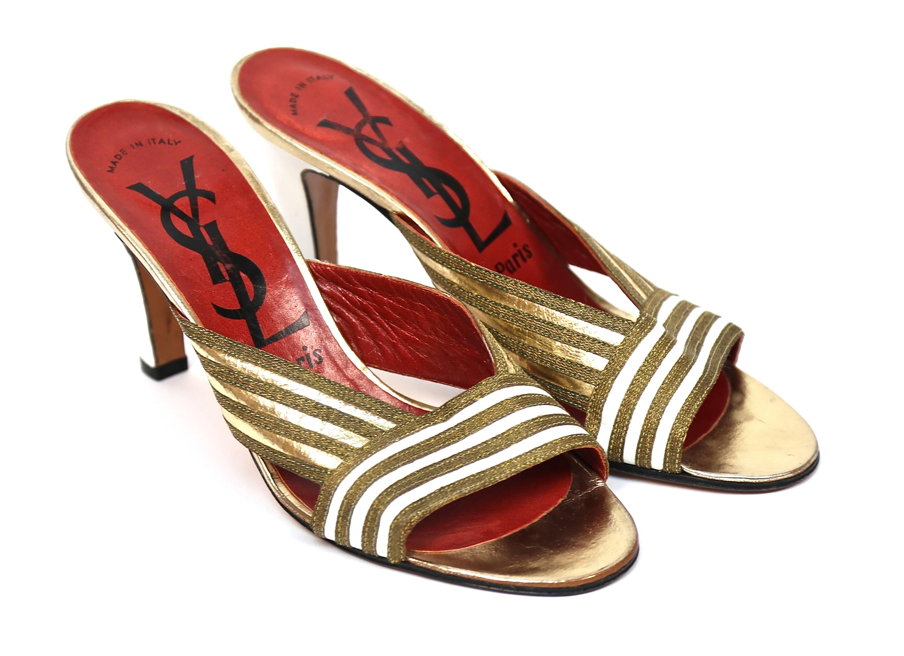 Magnifique et très rare paire de talons en or et en cuir blanc d'Yves Saint Laurent datant de la fin des années 1970. 

Taille. 6.5. Les semelles mesurent environ 9,5