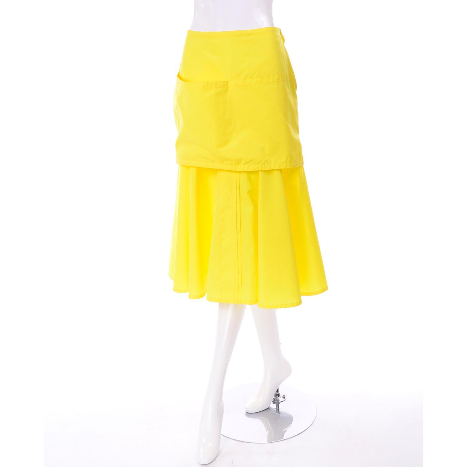 This is a very unique Gianni Versace bright yellow skirt with the original tags! It is a flared skirt, with a connected piece that looks like a mini skirt! It has one large pocket on the right side of the shorter skirt, giving it the look of an
