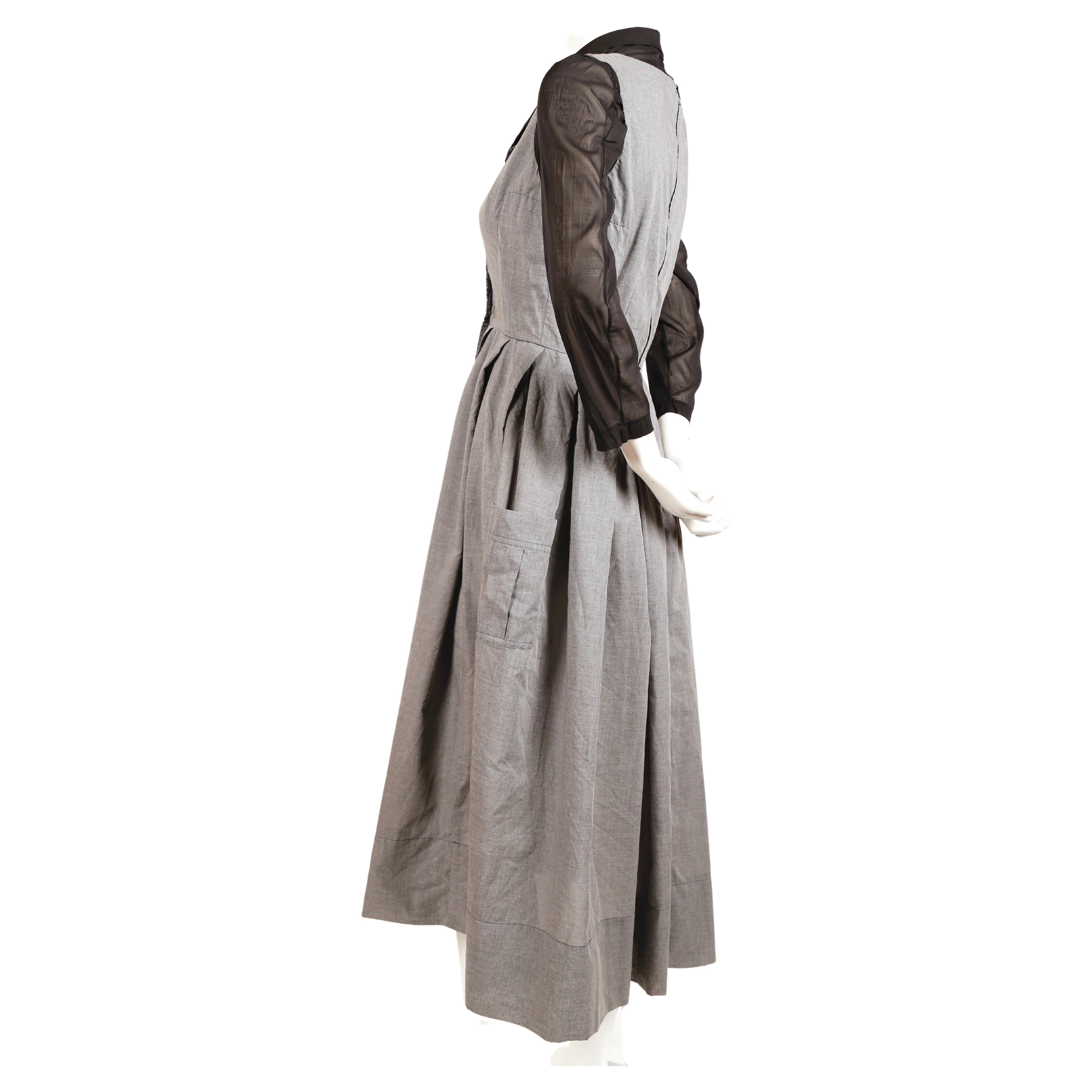Heathered-grey and black double layer dress with safety pin closure designed by Rei Kawakubo for Comme Des Garcons dating to spring of 2000 as seen on the runway. Labeled a size M however this dress best fits an XS or 32
