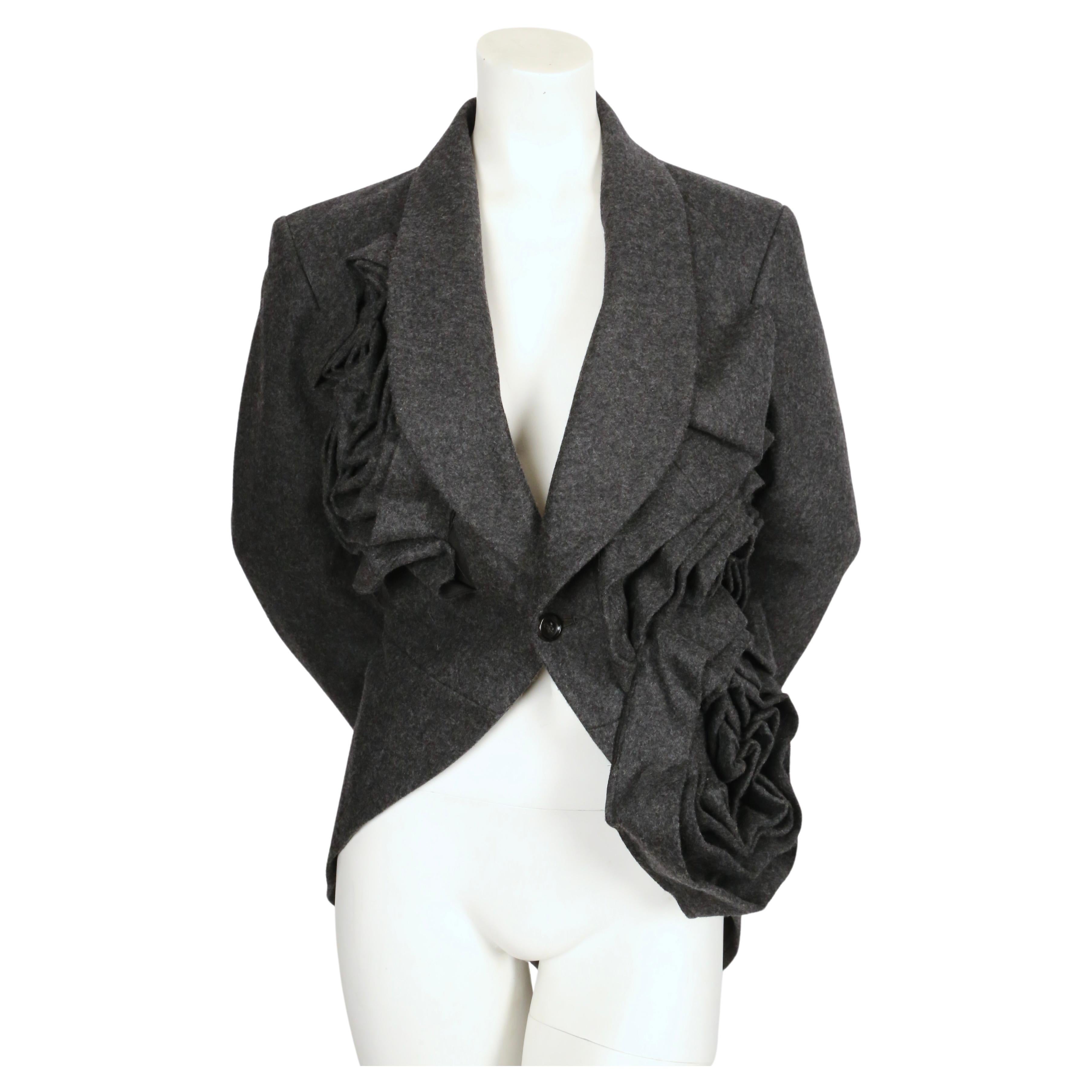 Very dramatic asymmetrical grey wool jacket with oversized rose motif designed by Rei Kawakubo. Similar jackets were seen on the spring 2013 runway. Jacket has a 'tuxedo' style fit with a shorter front that back.  Labeled a size 'm'. Approximate