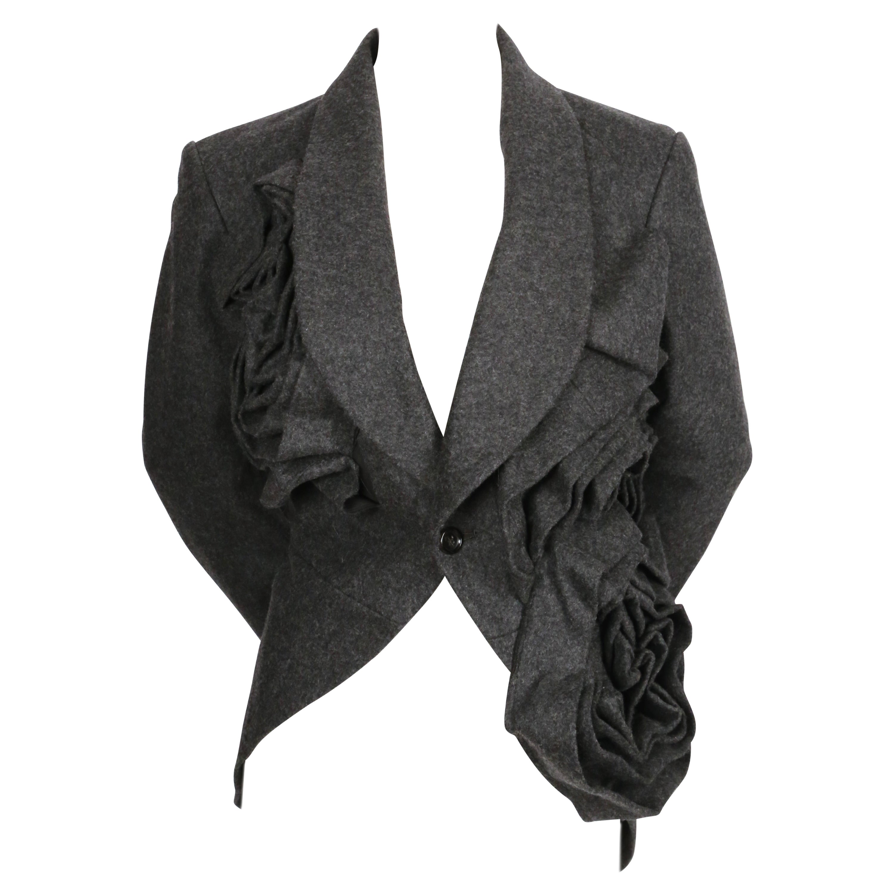 Very dramatic, asymmetrical grey wool jacket with oversized rose motif designed by Rei Kawakubo. Similar jackets were seen on the spring 2013 runway. Jacket has a 'tuxedo' style fit with a shorter front that back.  Labeled a size 'M'. Approximate