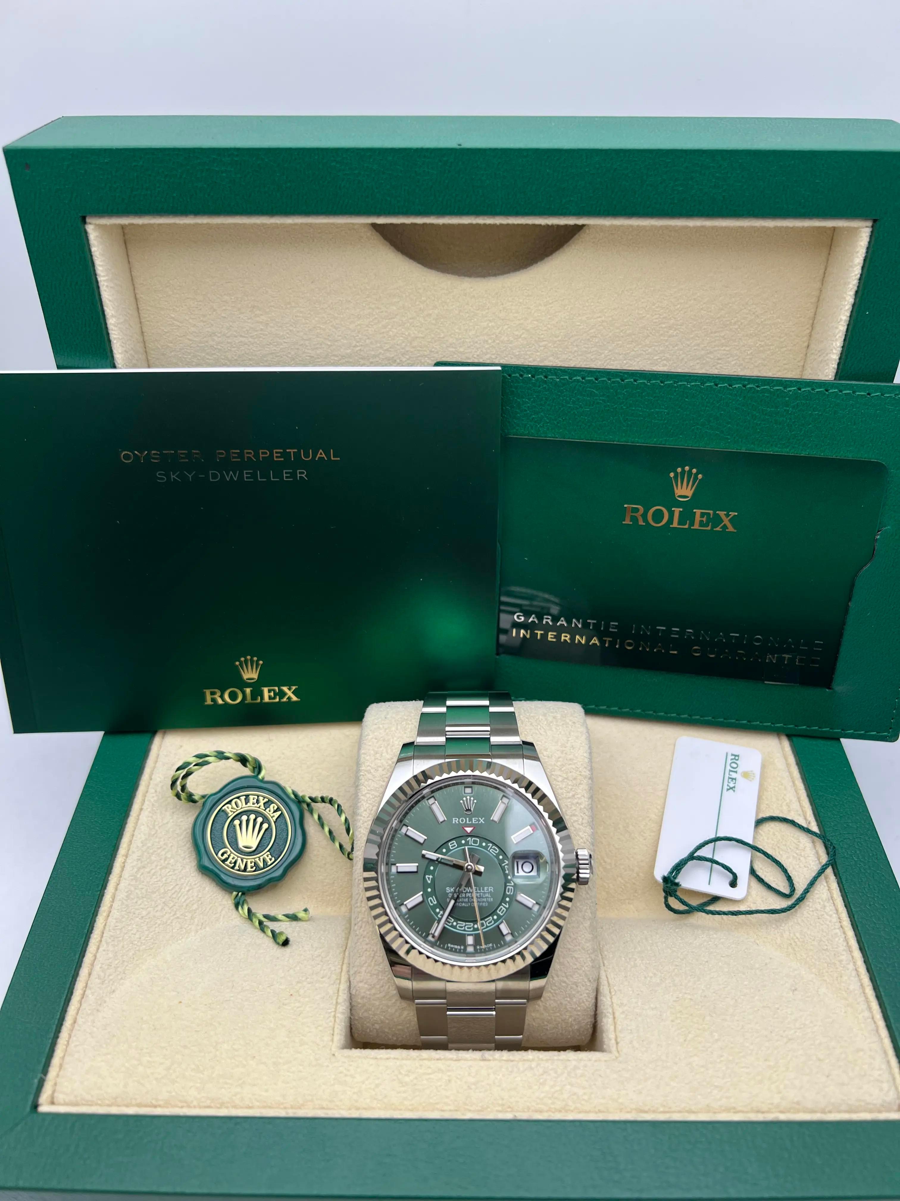 Brand New 2025, Rolex Sky-Dweller 336934, featuring a 42mm stainless steel case with an 18K white gold fluted Ring Command bezel. Stunning green dial with dual time display, off-center 24-hour disc, and annual calendar with month indicators around