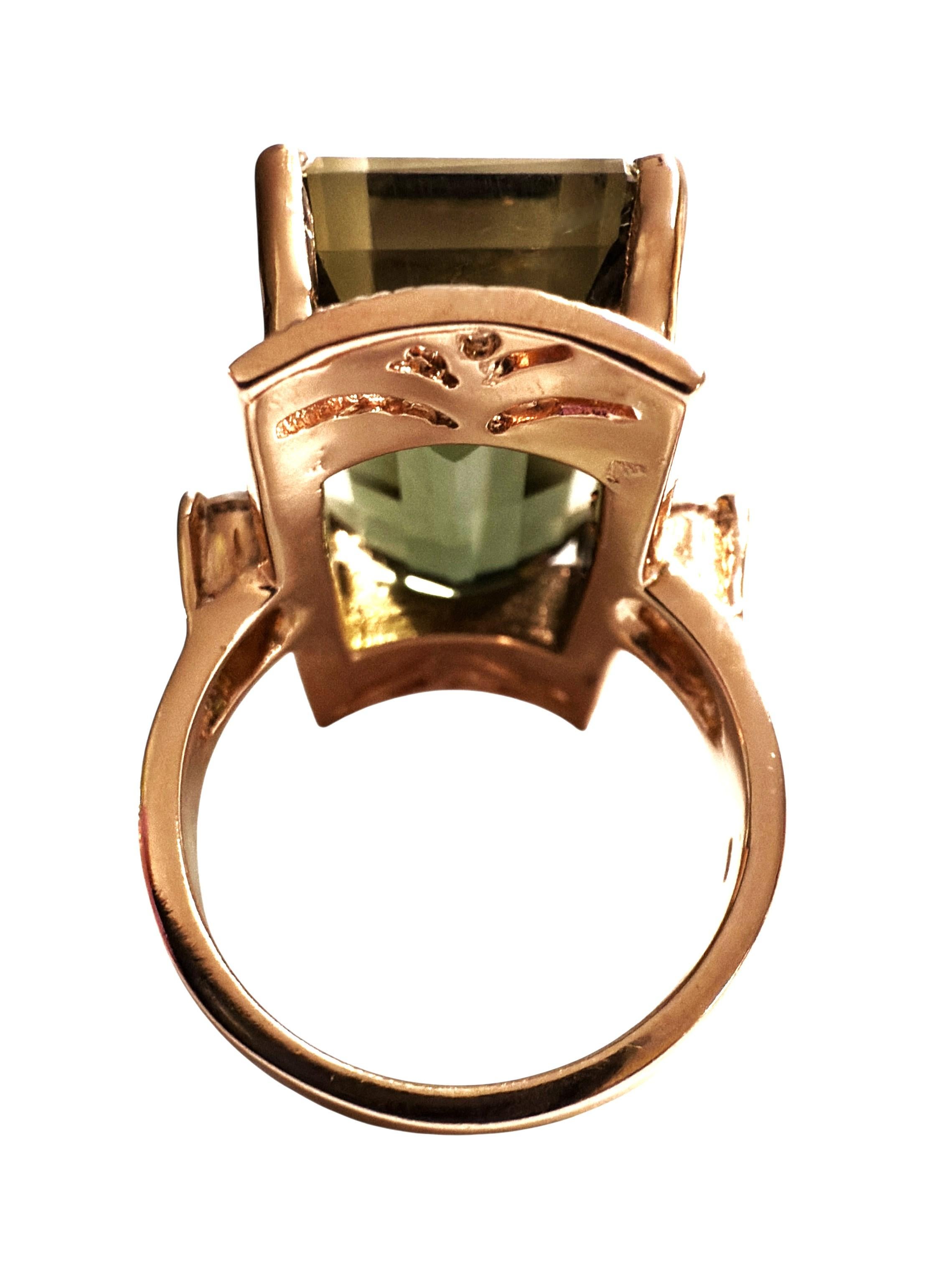 The stone is from Africa and is just beautiful especially in this gorgeous setting. The stone is a deep green tourmaline and is 22.10 carats.  The stone is a
large baguette cut stone and measures 19.3 x 13.3 mm.  It has a diamond cut white sapphire
