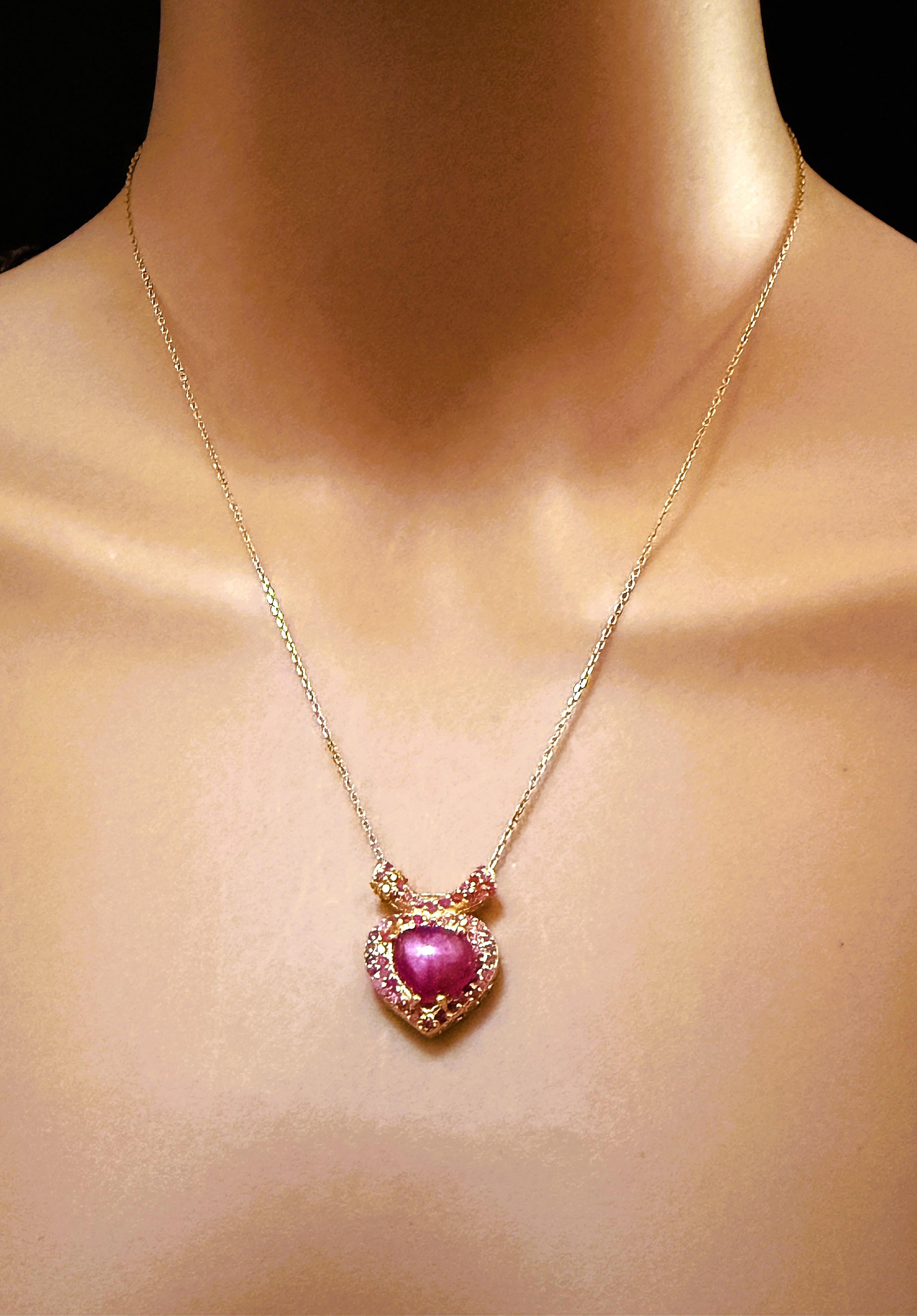 This necklace is just gorgeous and unique. It has a Heart-Shaped Ruby Cabochon Centerstone that measures 10 x 9 x 4 mm and it totals 2.63 carats.  It is surrounded by 2 rows of diamond cut rubies and they run up the split bail as well.  They are set