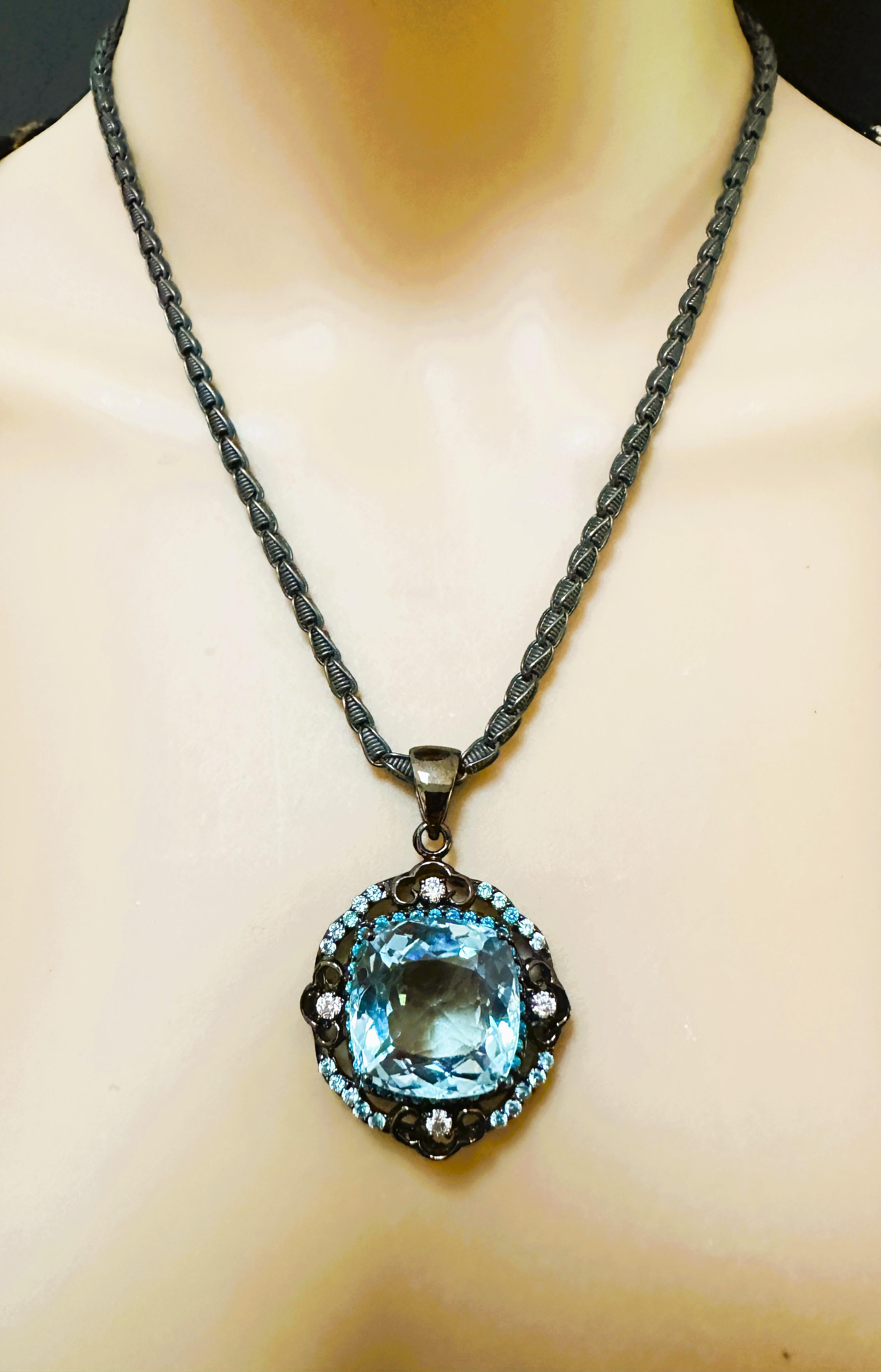 What a magnificent pendant!  It is just stunning!  The stone is from Brazil and is just exquisite. The stone is a large cushion cut Icy Blue Aquamarine and is 31 carats. It measures 20 x 20 mm and is surrounded by diamond cut blue topaz stones.  It