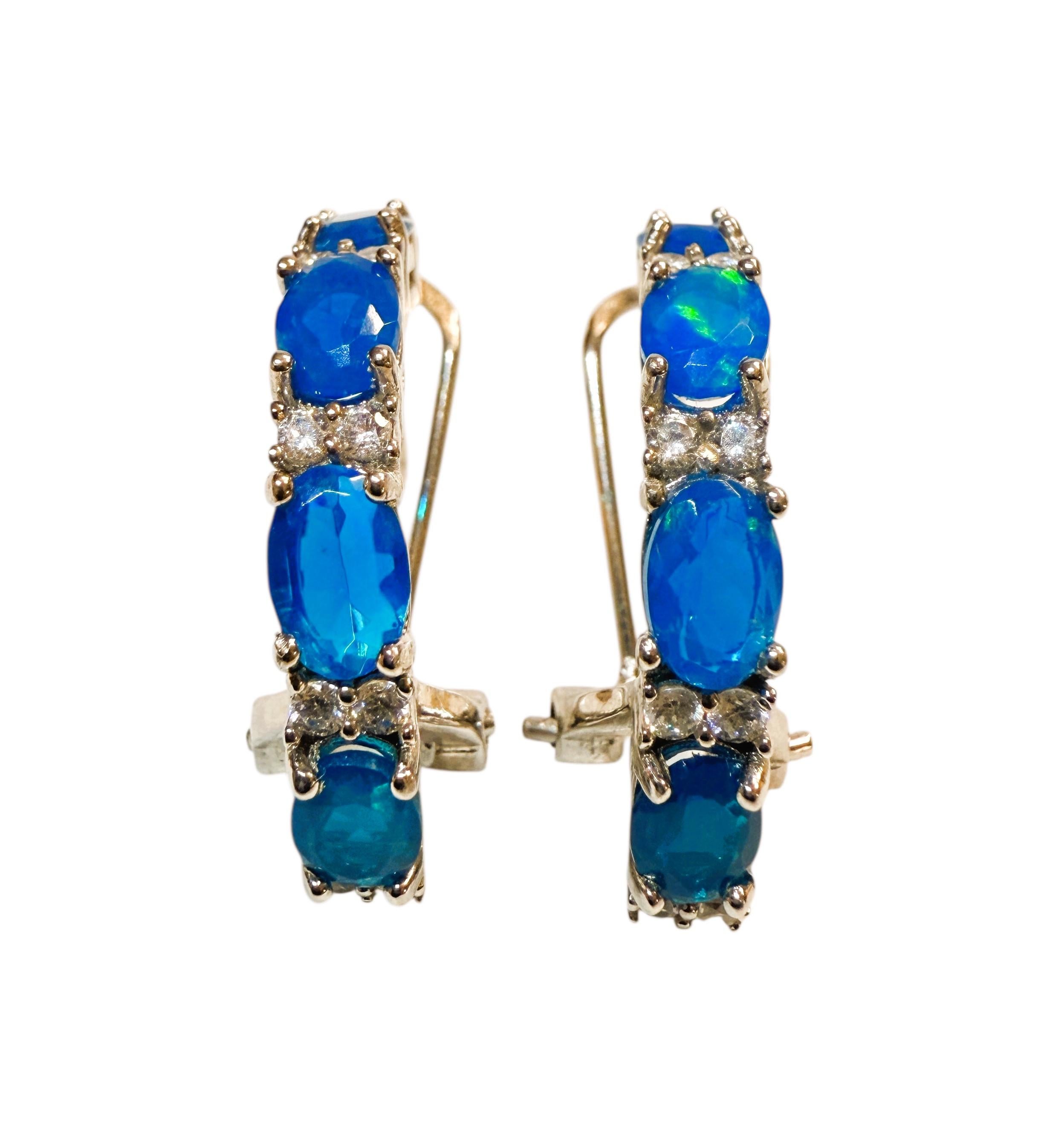 Diese Ohrringe sind einfach wunderschön!  Jeder Ohrring besteht aus vier 6 x 4 mm großen äthiopischen blauen Opalsteinen im Ovalschliff.  Insgesamt sind es 3.44 Karat.  Zwischen jedem Opal liegen 2 weiße Saphire im Diamantschliff. Sie sind