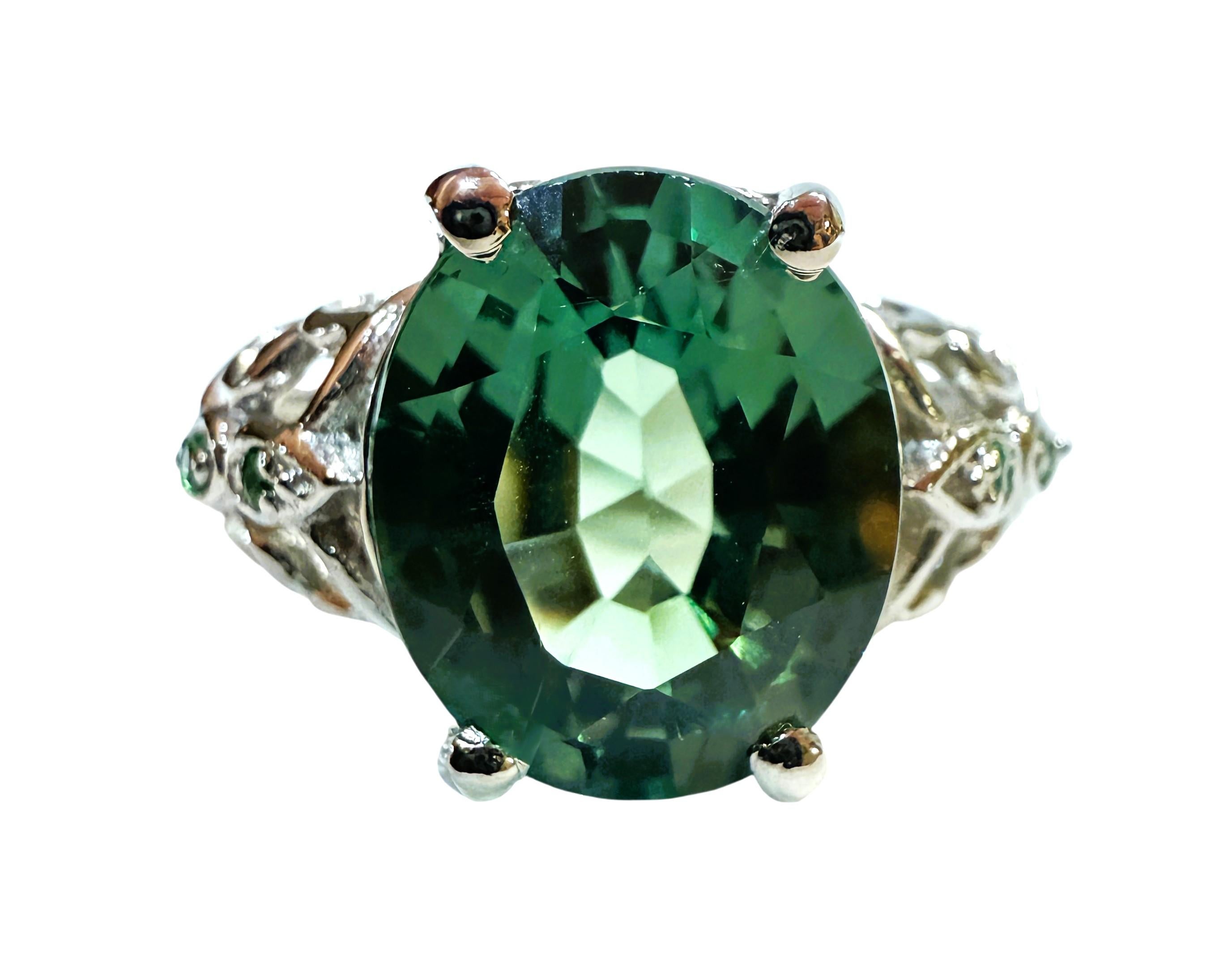 La piedra procede de África y es sencillamente exquisita. La piedra es un zafiro verde laguna y mide 4,70 quilates.  Es una piedra de talla redonda de fantasía, mide 11,3 x 9,5 mm y tiene zafiros verdes talla diamante que recorren los lados de la