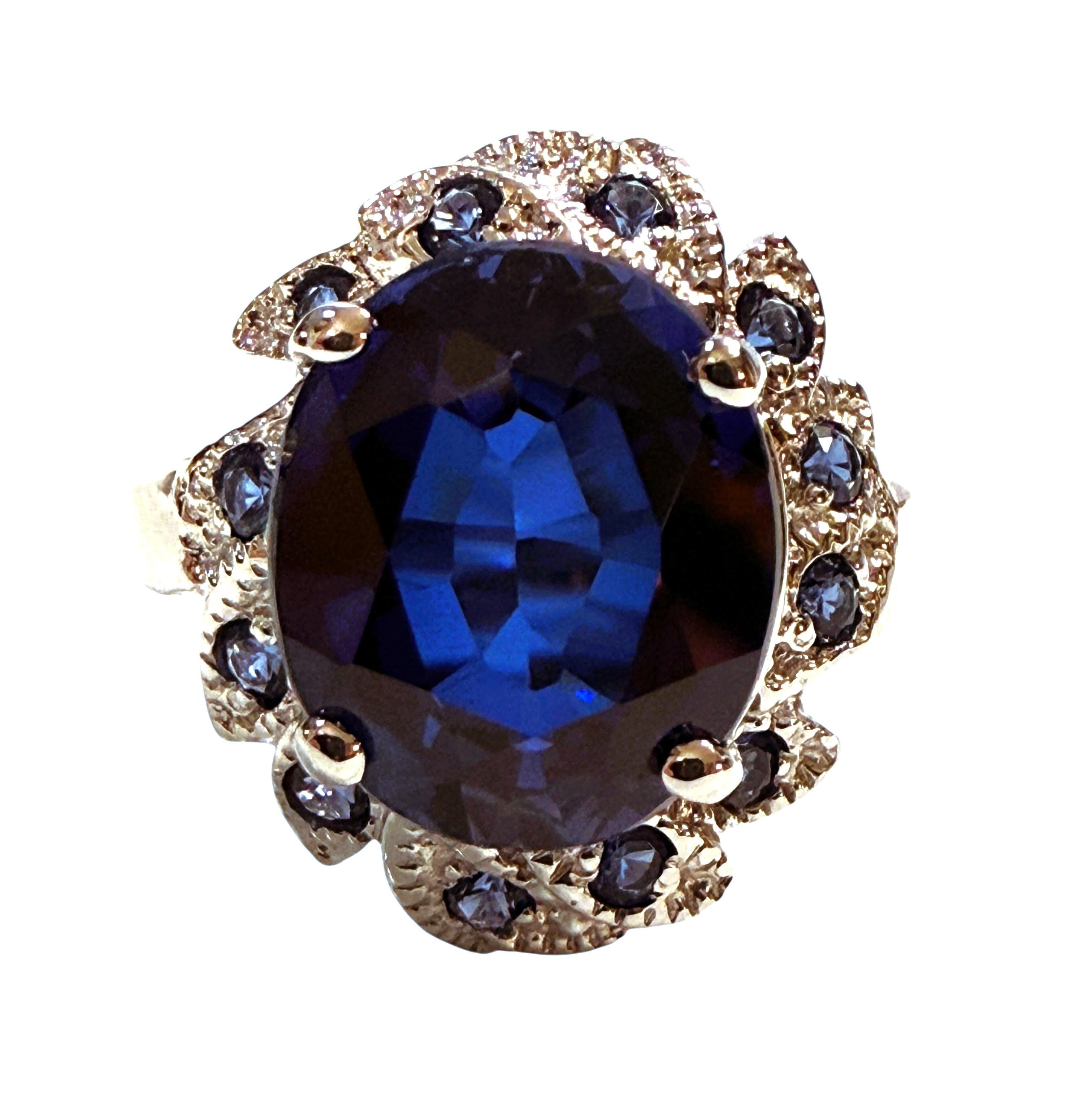 ¡Este anillo es simplemente impresionante!  Es una talla 7,5 y la piedra es de Sri Lanka.  El anillo tiene un zafiro central ovalado de 5.50 quilates.  Mide 11,5 x 9,6 mm y está rodeado de zafiros azules talla diamante.  Todas están engastadas en un