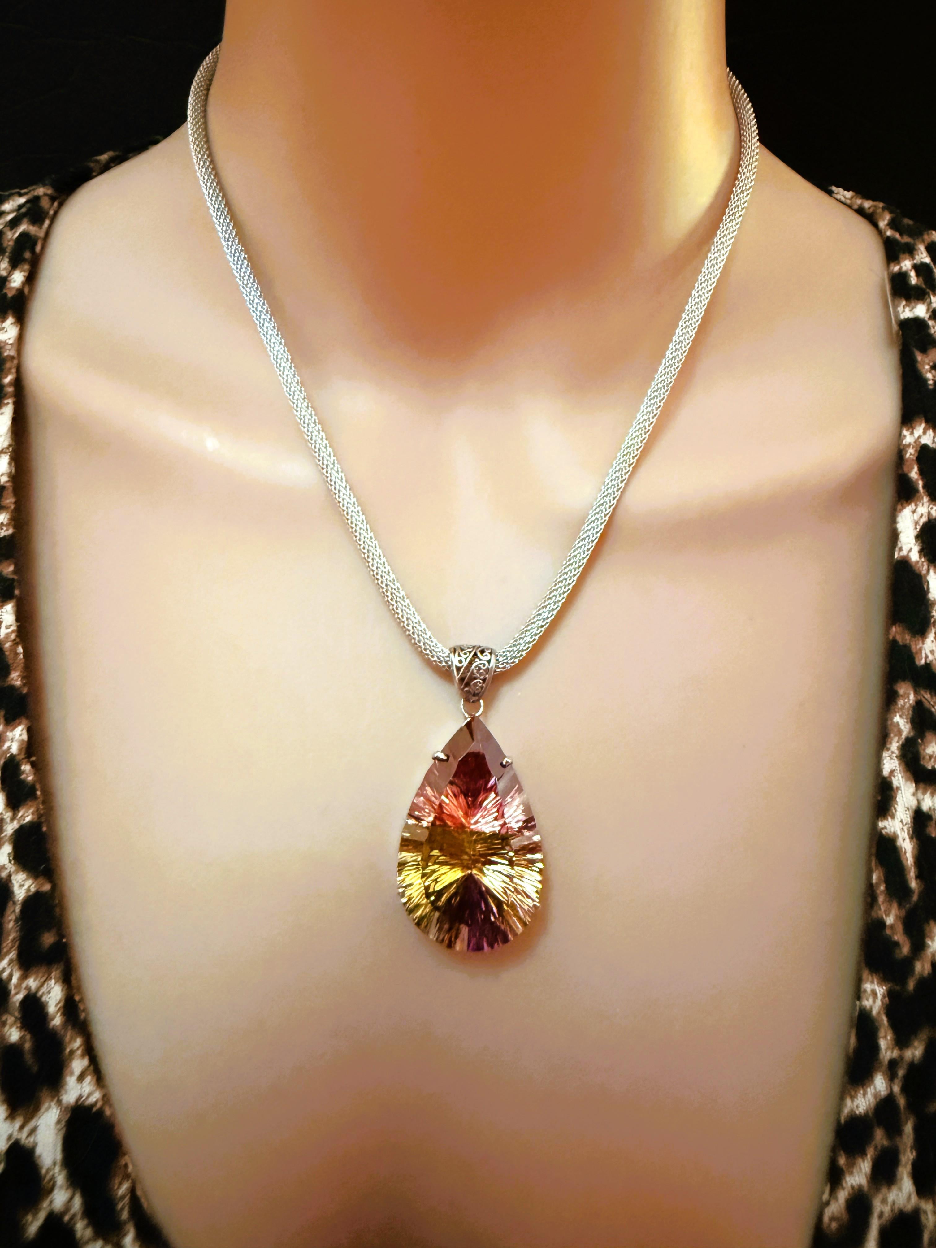 What a phenomenal pendant necklace!  The stone is a beautiful Fantasy Honeycomb Pear cut stone and is a whopping 59.80 carats.  it has so many beautiful colors in it, reds, oranges, browns, yellows, and purples.   It measures 33.4 mm long x 27.10 mm