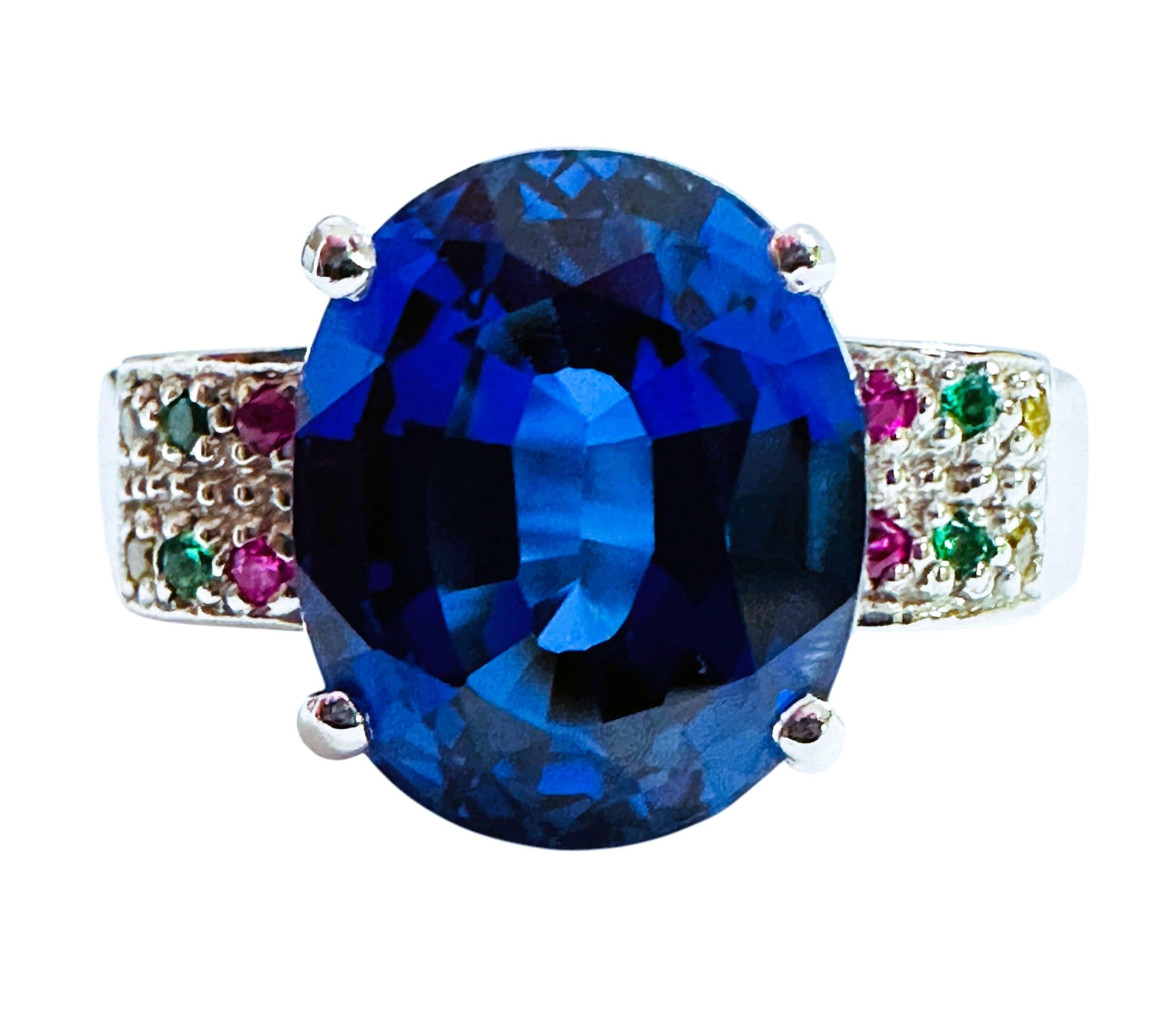 The stone is from Sri Lanka and is just beautifully cut.  It is a blue sapphire and is 7.75 cts.  It is a fancy oval cut stone and measures 12 x 9.8 mm and is flanked by 2 rows diamond cut Red, Blue and White sapphire stones on each side of the