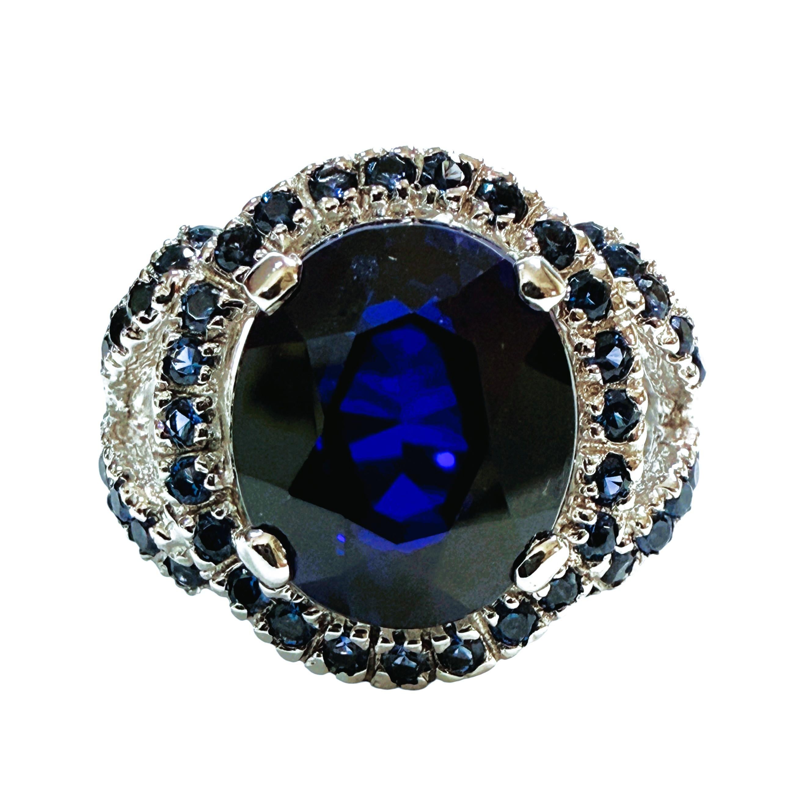 Questo anello è semplicemente stupendo!  È una taglia 7.  La pietra proviene dallo Sri Lanka.  L'anello ha uno zaffiro ovale centrale di 7.02 carati.  Misura 12,2 x 10,3 mm.  È circondato da splendidi zaffiri blu tagliati a diamante di un colore