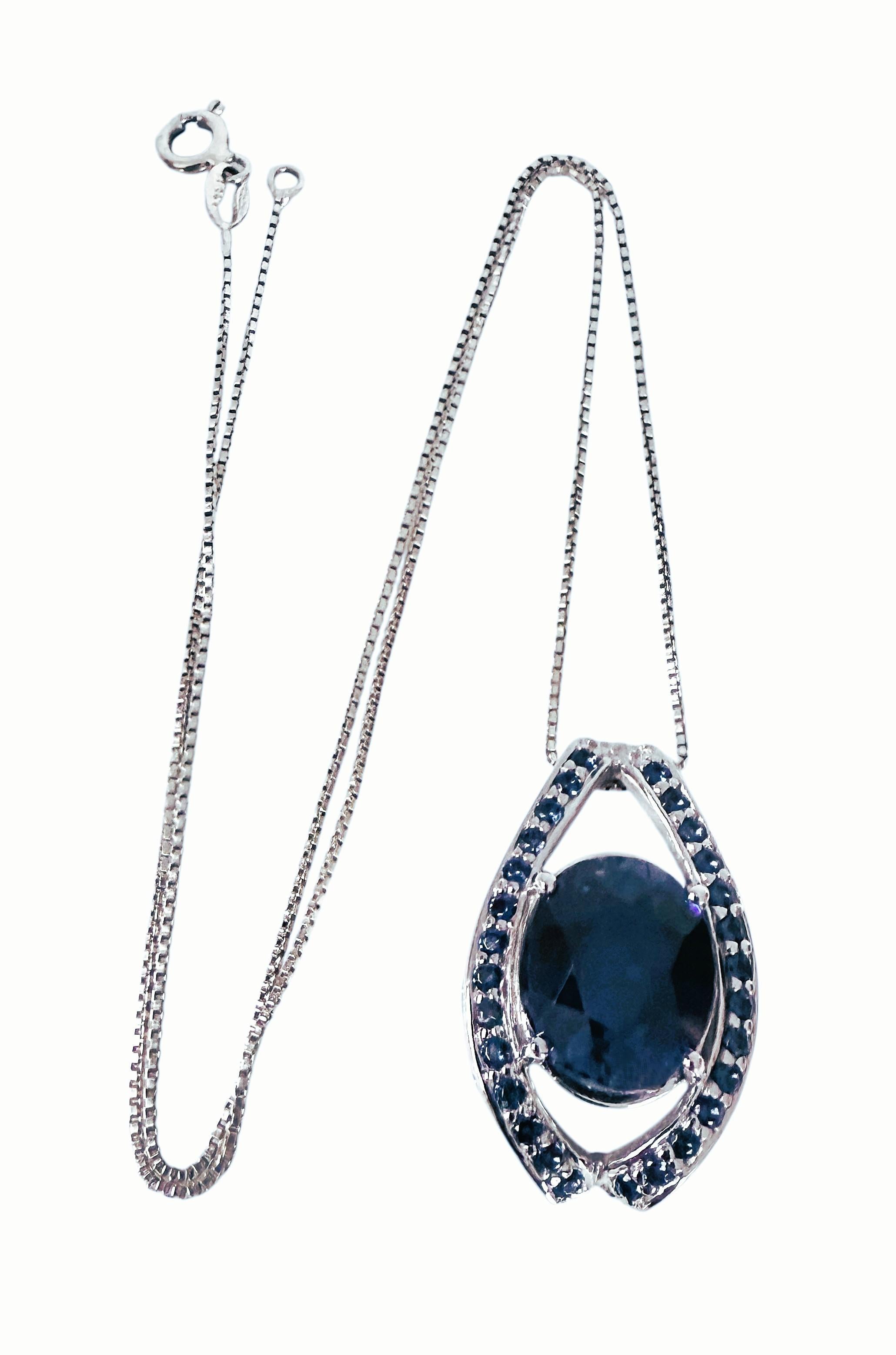 È una collana molto bella e ricca. La pietra proviene dall'Africa. Si tratta di una bellissima pietra dal taglio ovale di 7.60 carati. È una pietra di altissima qualità.  Misura 13,5 x 11,3 mm ed è circondato da zaffiri blu taglio diamante in un