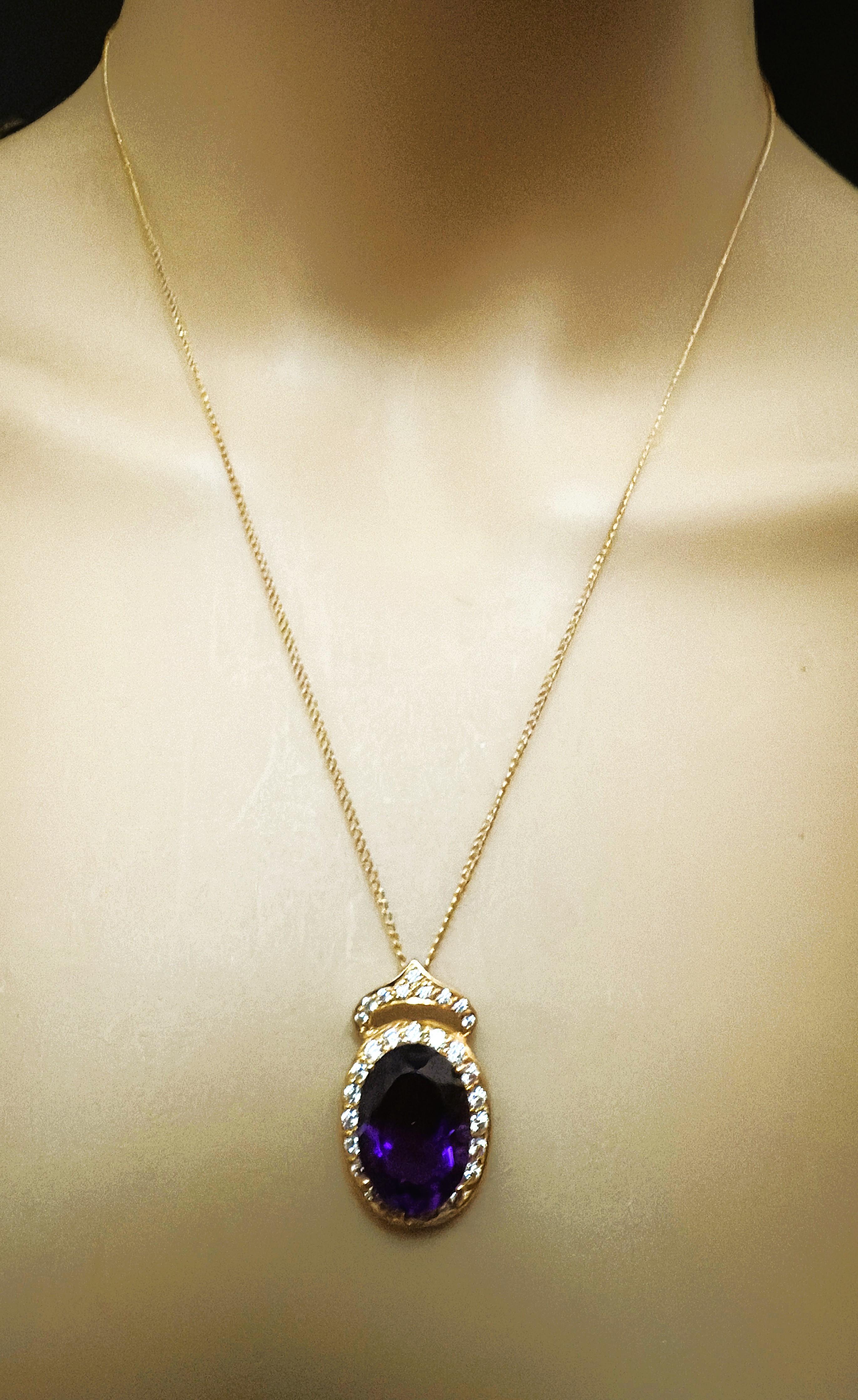 Der Stein stammt aus Brasilien und ist einfach exquisit. Der Stein ist ein Amethyst mit ovalem Schliff und hat 8.45 Karat. Er misst 16 x 12 mm und ist von weißen Saphiren im Diamantschliff umgeben.  Er hat auch eine Krone, die mit weißen Saphiren im