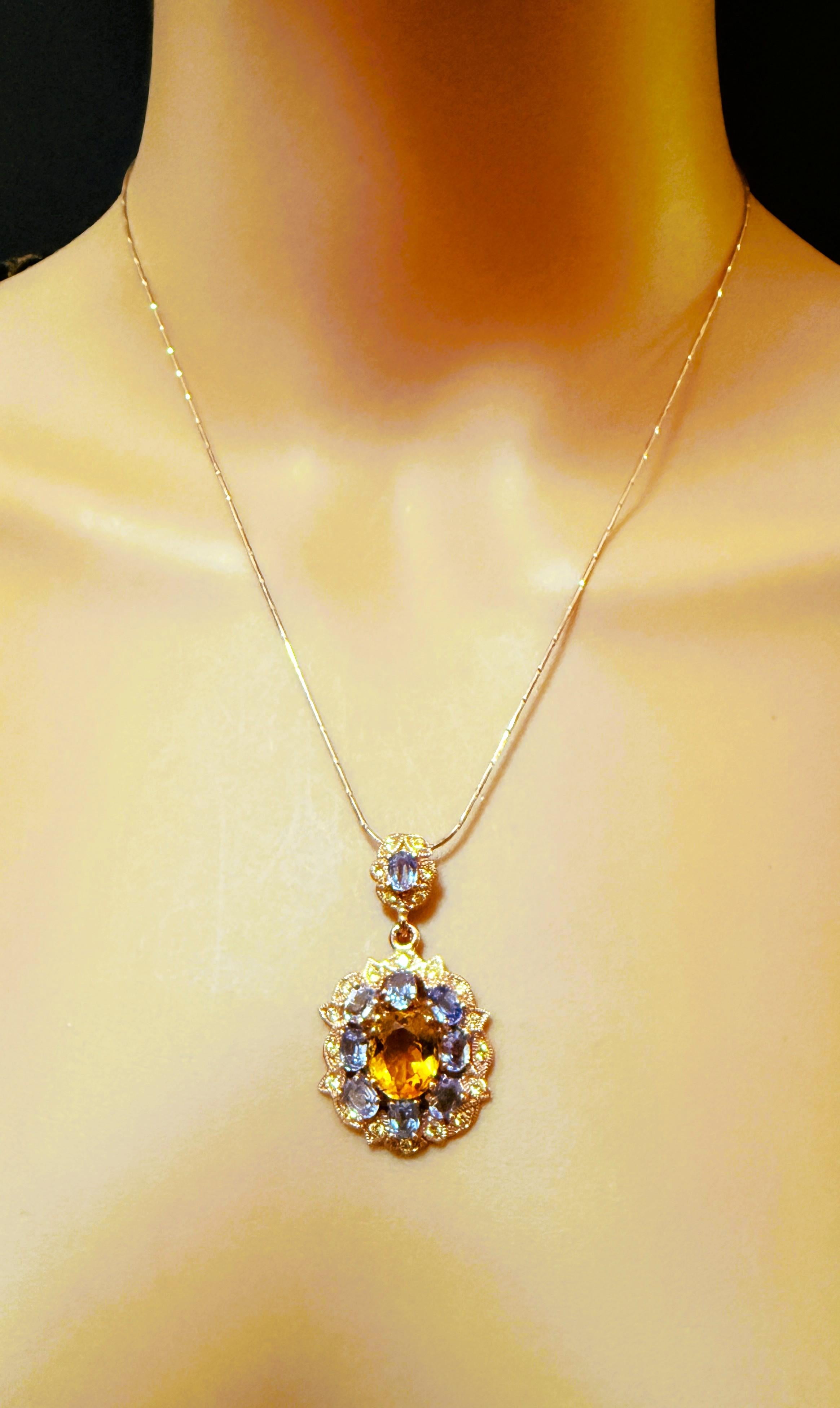 Che magnifico ciondolo!  La pietra centrale è un citrino ovale di 8,80 carati.  Misura 11 x 9 mm ed è circondata da 8 pietre ovali di tanzanite, di cui una sulla cauzione.  Lungo il bordo del ciondolo ci sono pietre di zaffiro color lime tagliate a