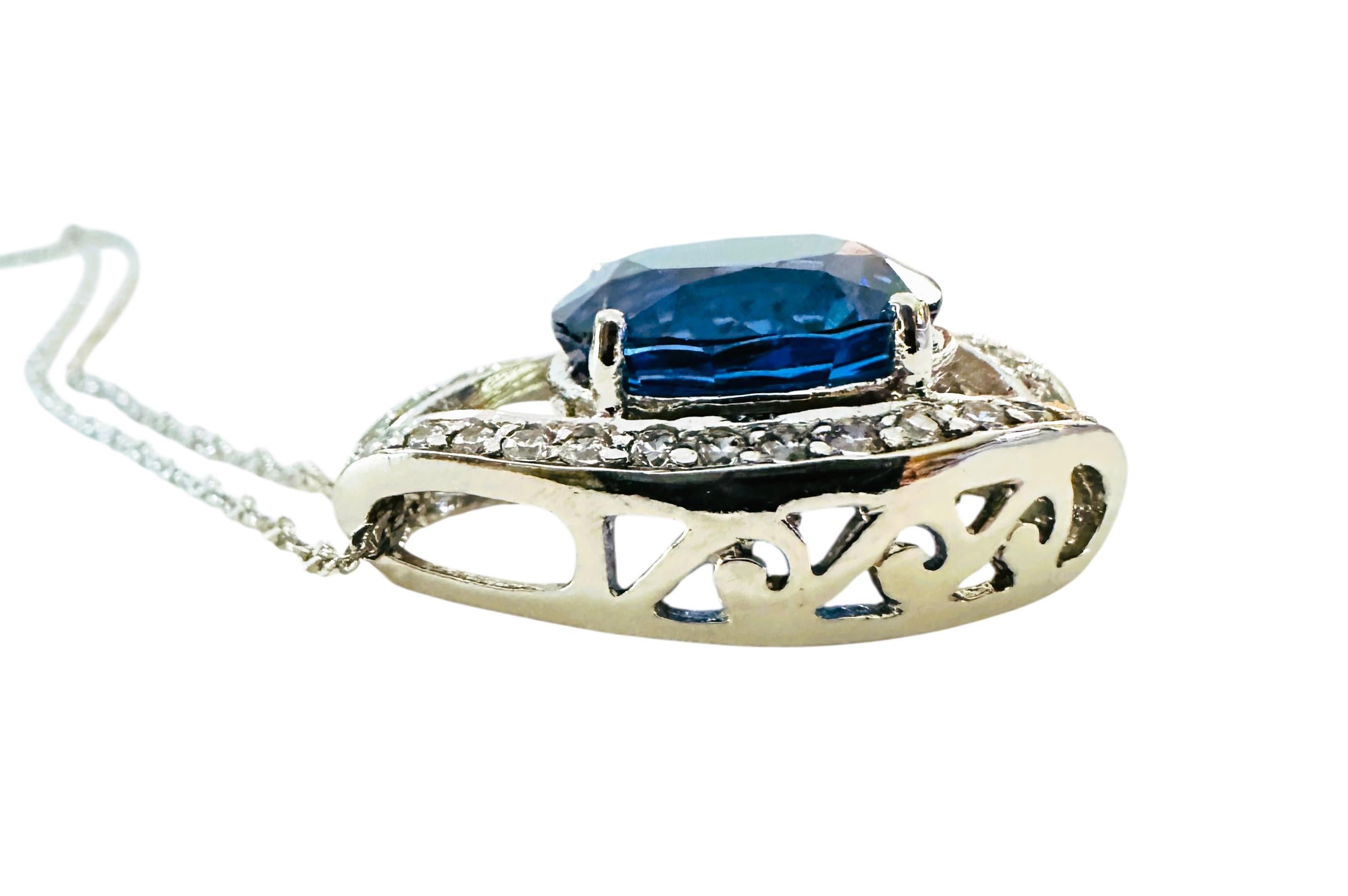 È una collana molto bella e ricca. La pietra proviene dall'Africa. Si tratta di una bellissima pietra dal taglio ovale di 9,60 carati. È una pietra di altissima qualità.  Misura 14 x 11,8 mm ed è circondato da zaffiri bianchi tagliati a diamante in
