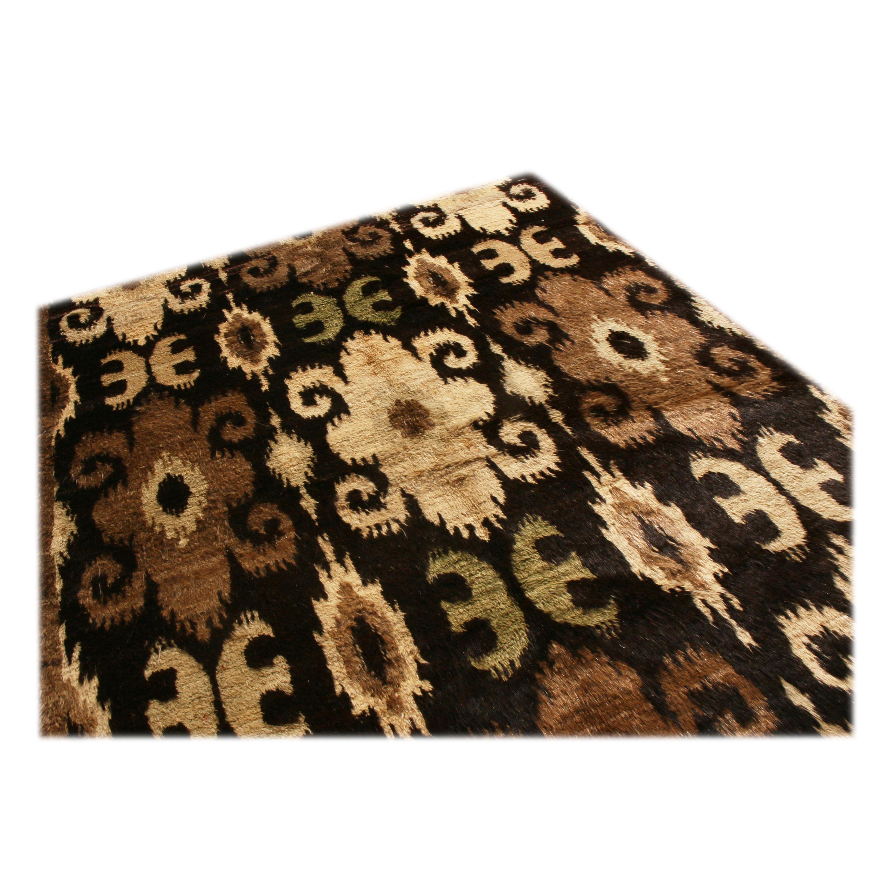 Originating from Afghanistan, this new Afghan wool rug is hand knotted in a thick, high-quality wool pile with a smoothness like that of goat hair. A deep black background within a rich brown wrapping guard border is complemented by beige, chestnut