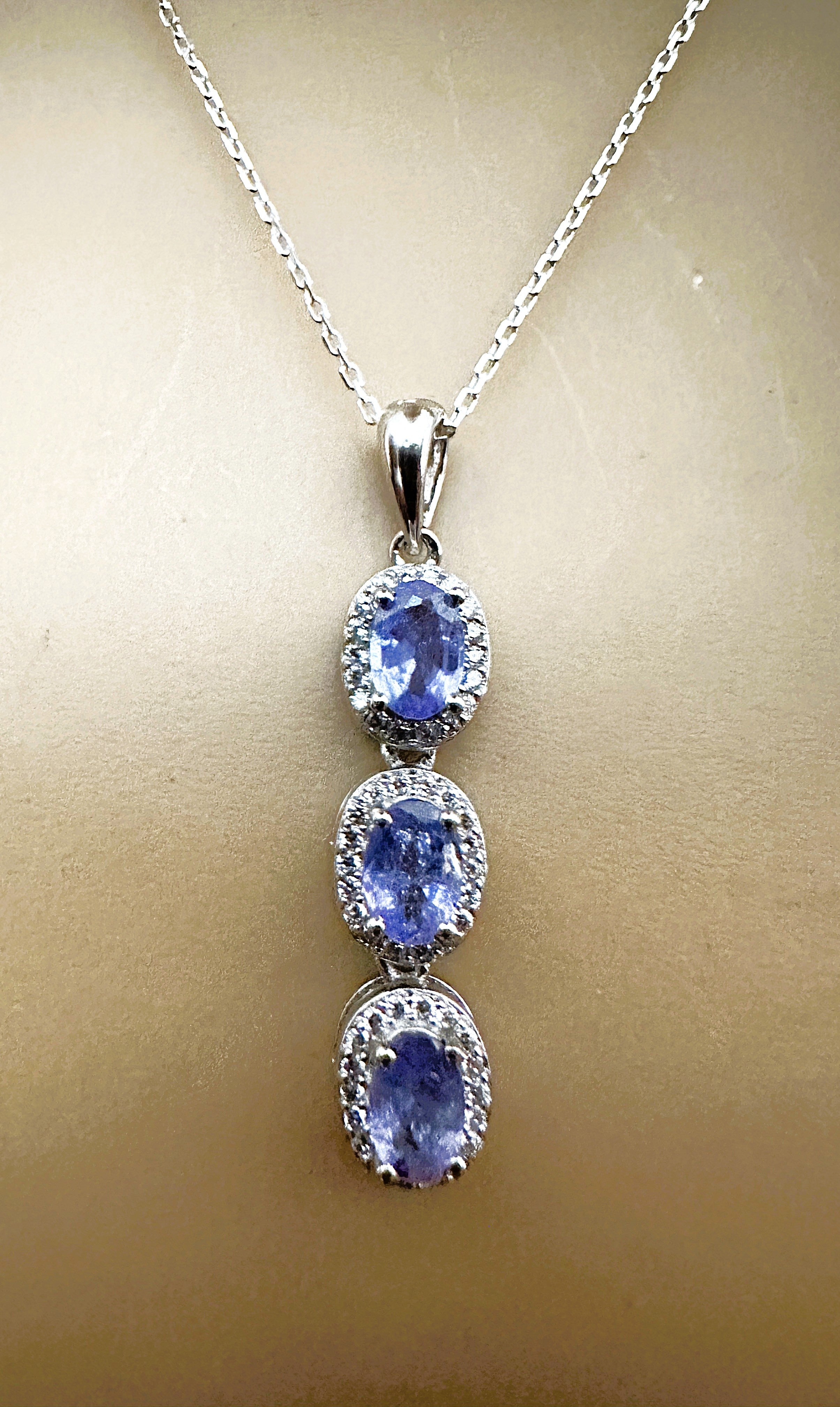 The stones are from Africa and is just exquisite. The 3 stones total 1.30 cts.  They are oval cut stones and measures 6.1 x 4 mm and each s surrounded by diamond cut white sapphires.  They are in a beautiful Sterling Silver setting.   The pendant