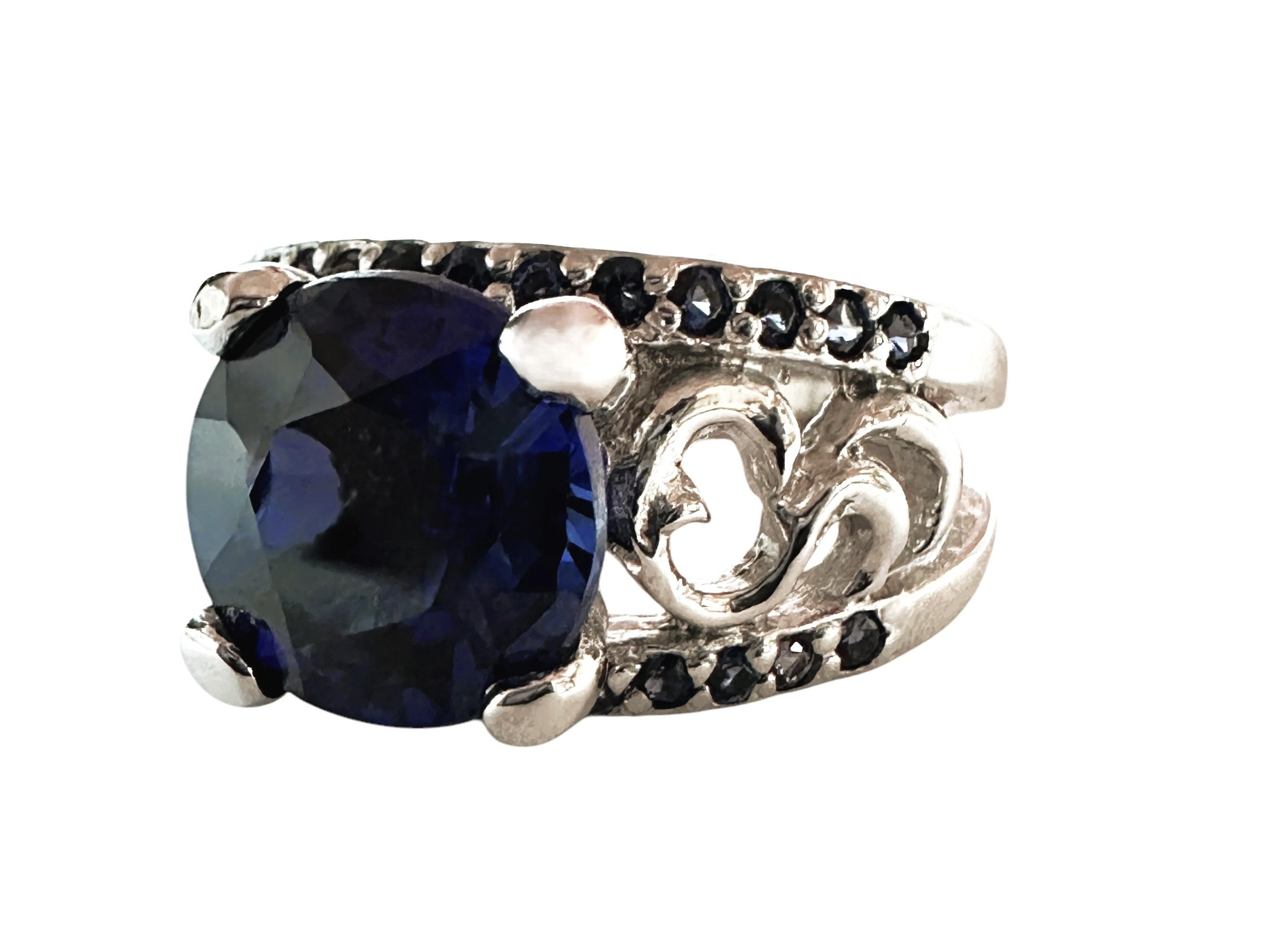 This ring is just stunning!  What great color combinations it has.  It is a size 6.25.  The center stone is 2.50 carats and measures 8.x 8 mm.  It has diamond cut blue sapphire stones running in a 