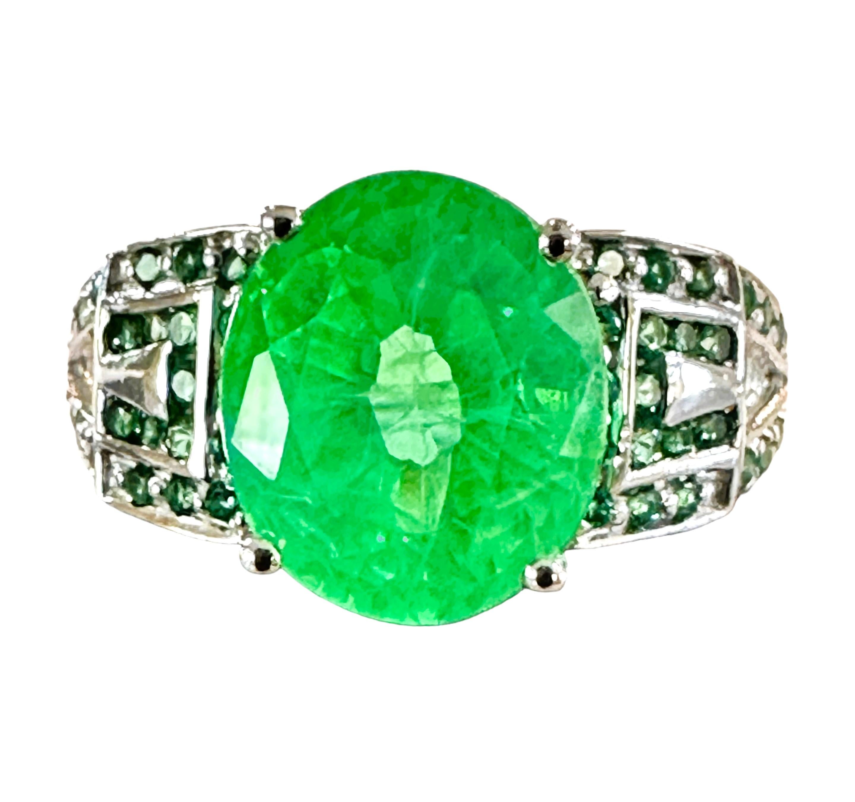 What beautifully constructed ring.  The ring is a size 6.   The stone is from Africa and is just exquisite.  It is a highly rated stone.  It is an oval cut stone and is 4.0 Cts   The main stone is 10 x 8.5 mm and is flanked by Diamond Cut Green