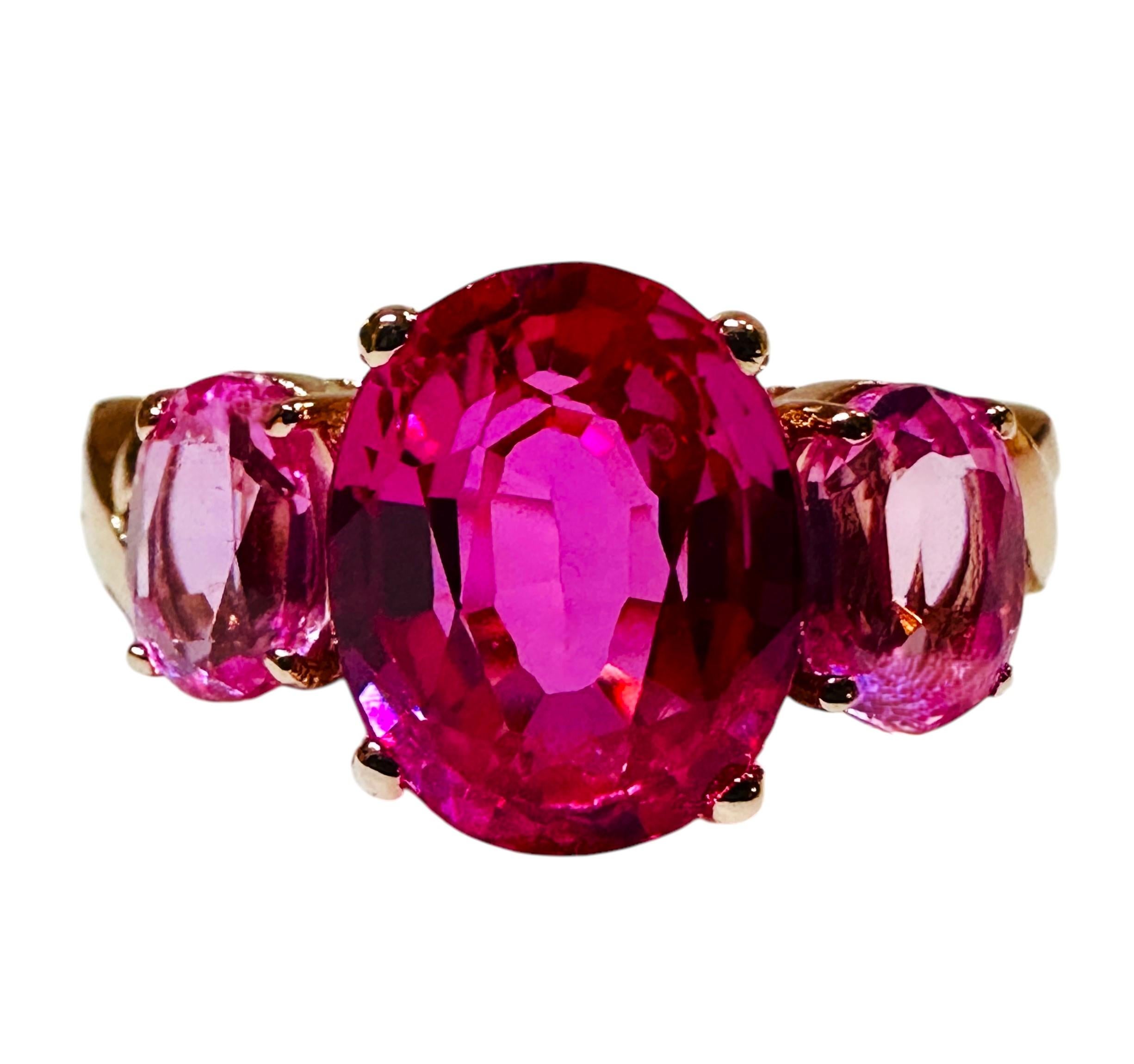 This ring is just stunning!  What great color combinations it has.  It is a size 7.25.  The 3 center stone is 4.40 carats and measures 10.x 7.8 mm.  It is flanked by 2 oval cut light pink sapphire stones and set in a beautiful rose gold plated