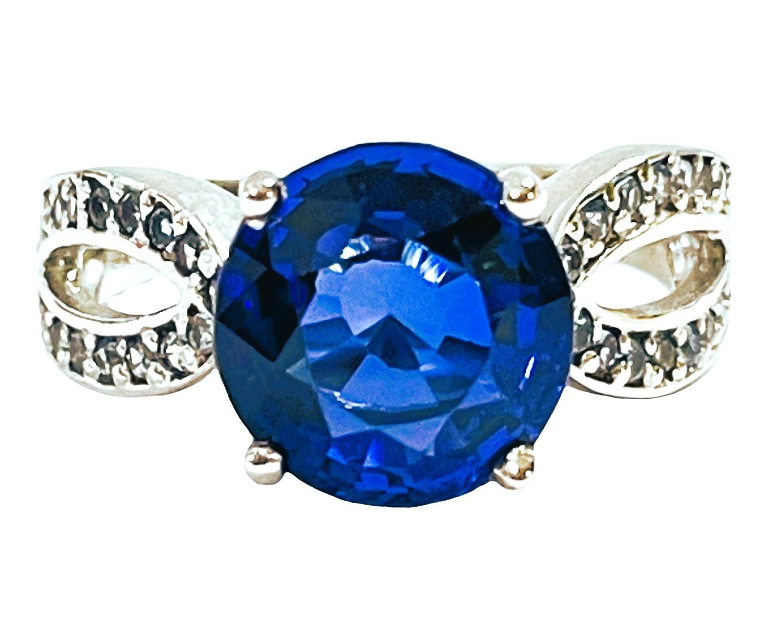 The ring is a size 7.25 and has just a beautiful setting..  It was mined in Africa.  It is an authentic natural stone.  It is a very high quality stone. The stone is a round cut stone and is 5.2 cts.  It is flanked by diamond cut Lighter Blue