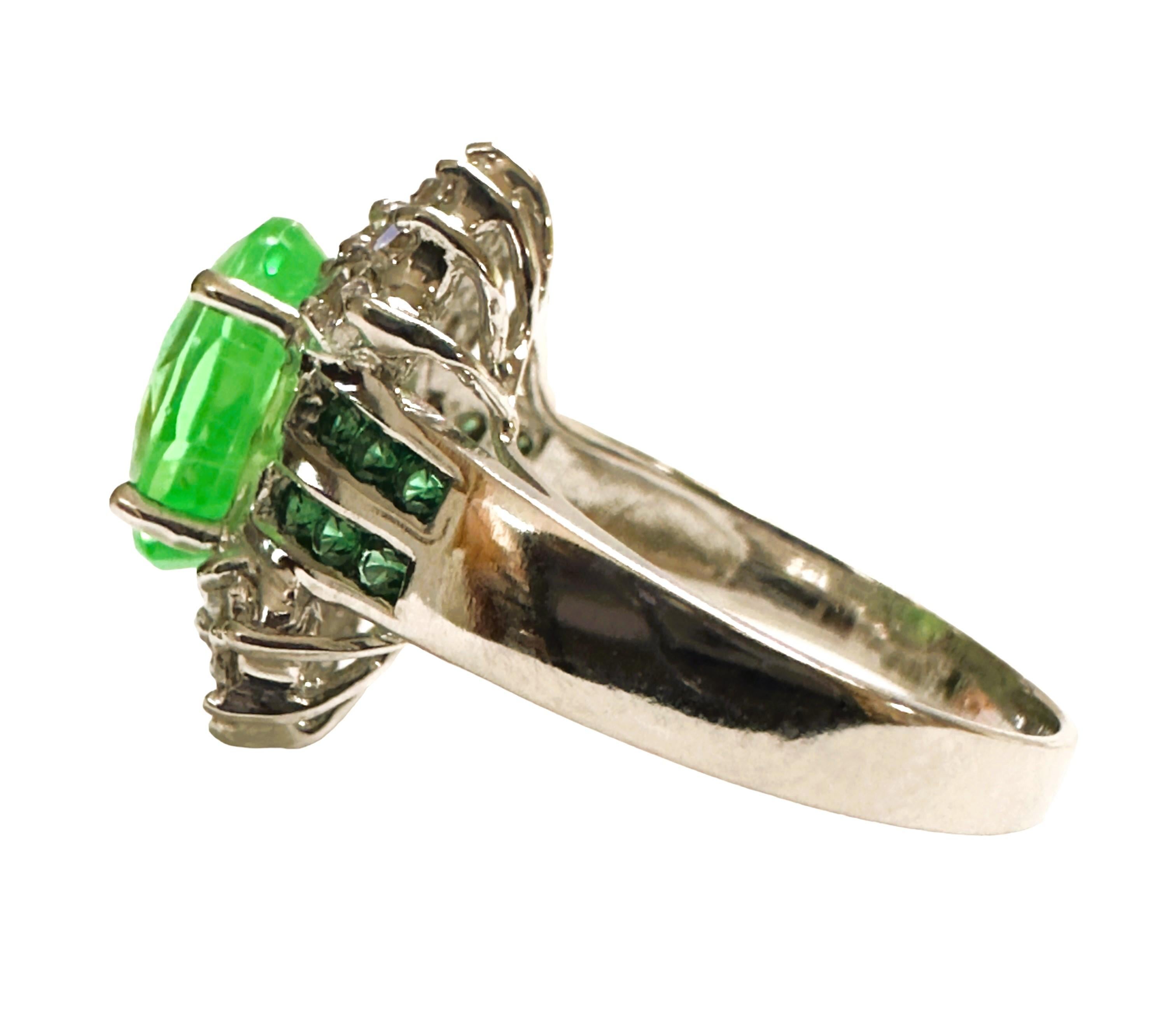 What beautifully constructed ring.  The ring is a size 7.25.   The stone is from Africa and is just exquisite.  It is a highly rated stone.  It is an oval cut stone and is 5.6 Cts   The main stone is 11 x 9 mm and is flanked by Diamond Cut Green