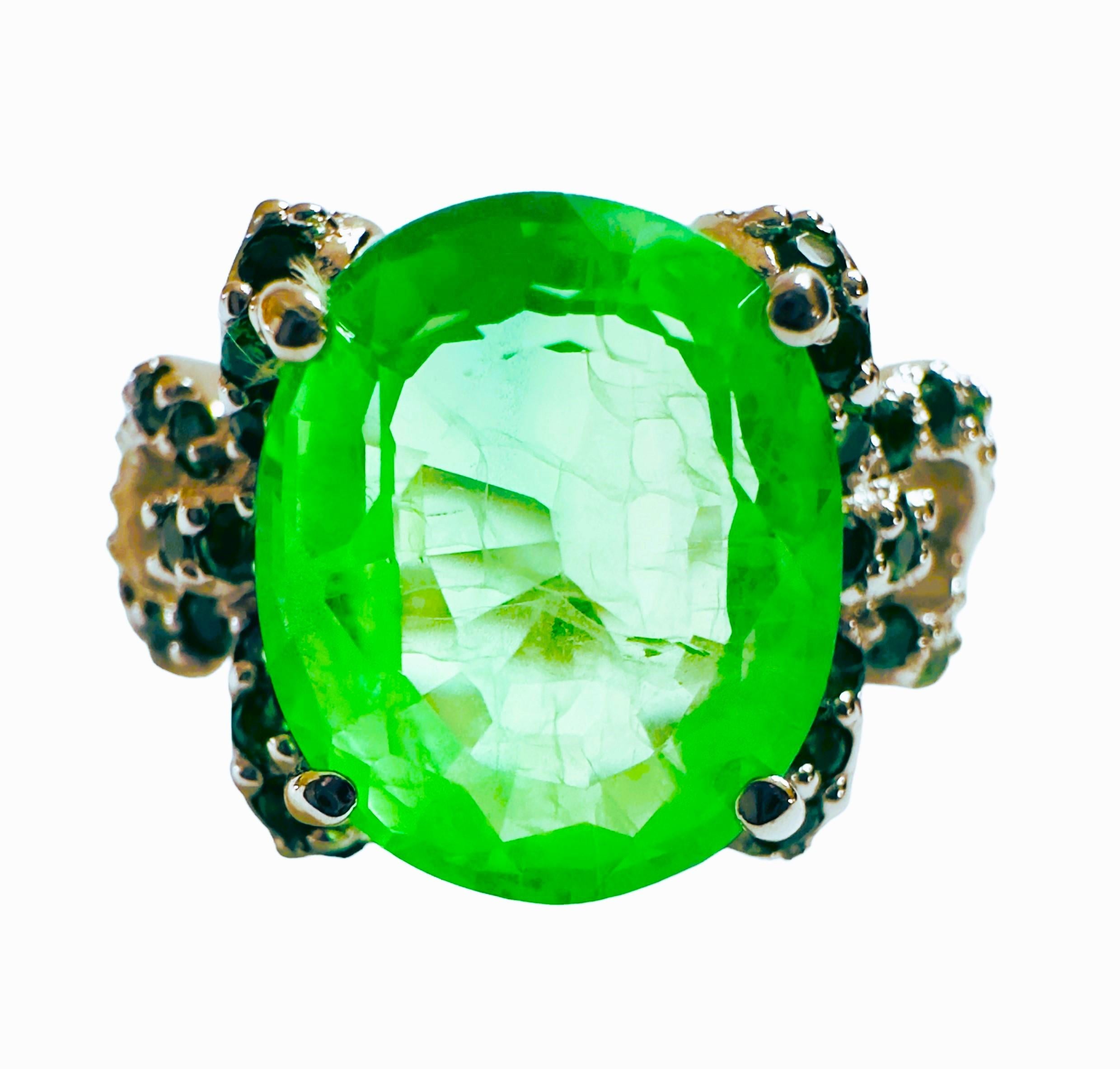 What beautifully constructed ring.  The ring is a size 6.5.   The stone is from Africa and is just exquisite.  It is a highly rated stone.  It is an oval cut stone and is 6.60 Cts   The main stone is 12.2 x 10.0mm and is flanked by Diamond Cut Green