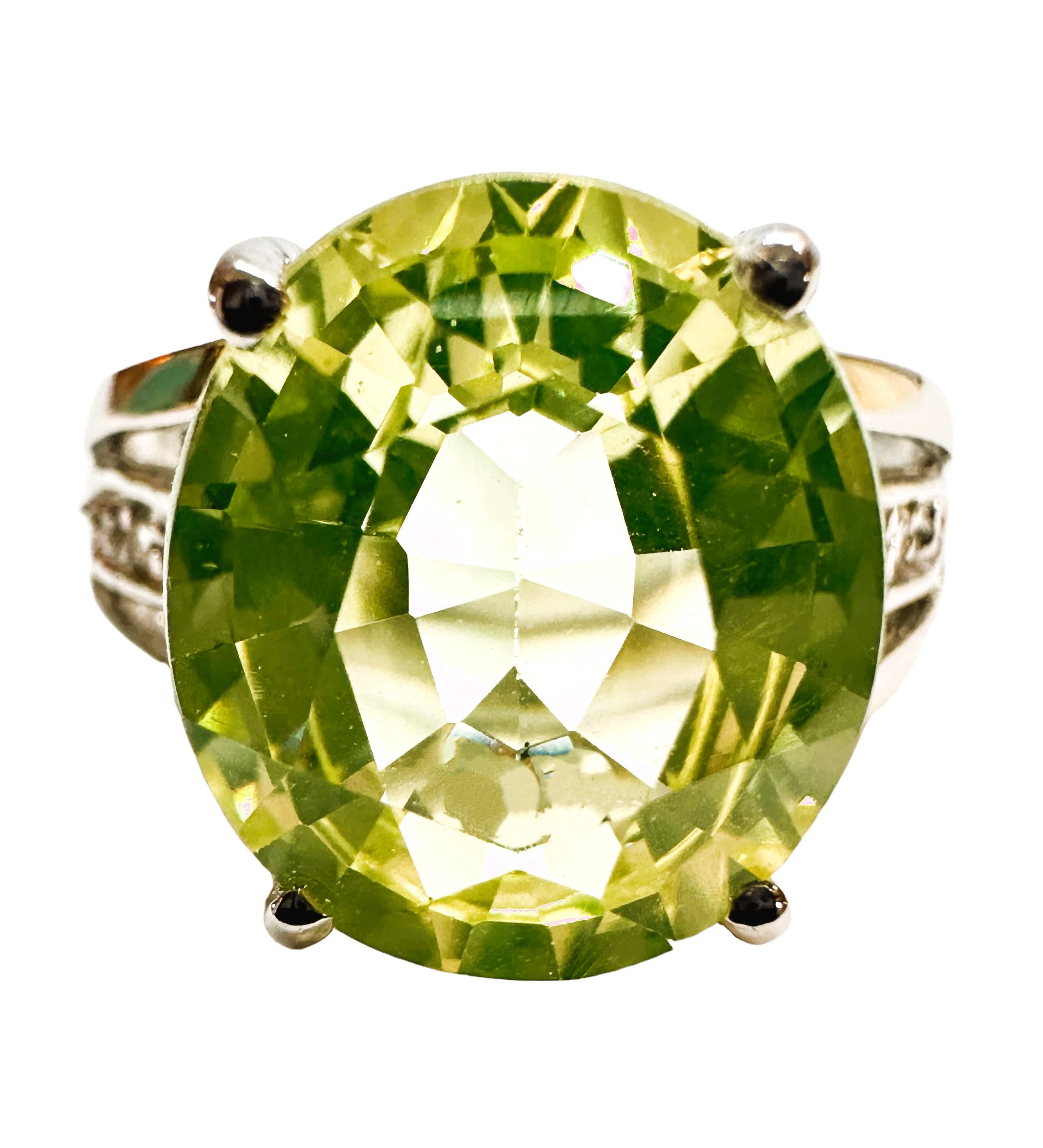 This is a very cool looking ring. This stone is from Africa and just a beautiful color of green.  The ring is a size 6.   It is an oval cut stone totalling 7.40 carats and has diamond cut white sapphires running down each side of the band.  The