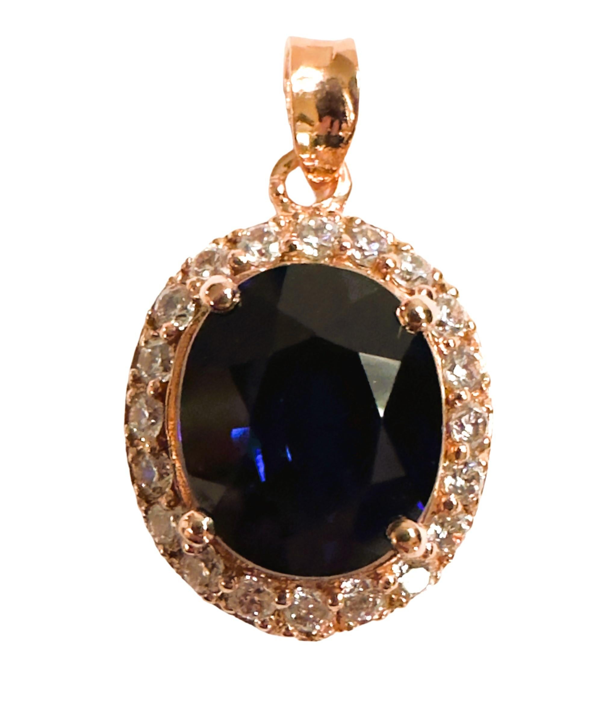 Der Saphirstein stammt aus Afrika und ist einfach exquisit. Es schimmert und funkelt einfach.  Der Stein ist oval geschliffen und misst 12 x 10 mm.   Er ist von diamantgeschliffenen weißen Saphiren umgeben. Der Anhänger ist 1
