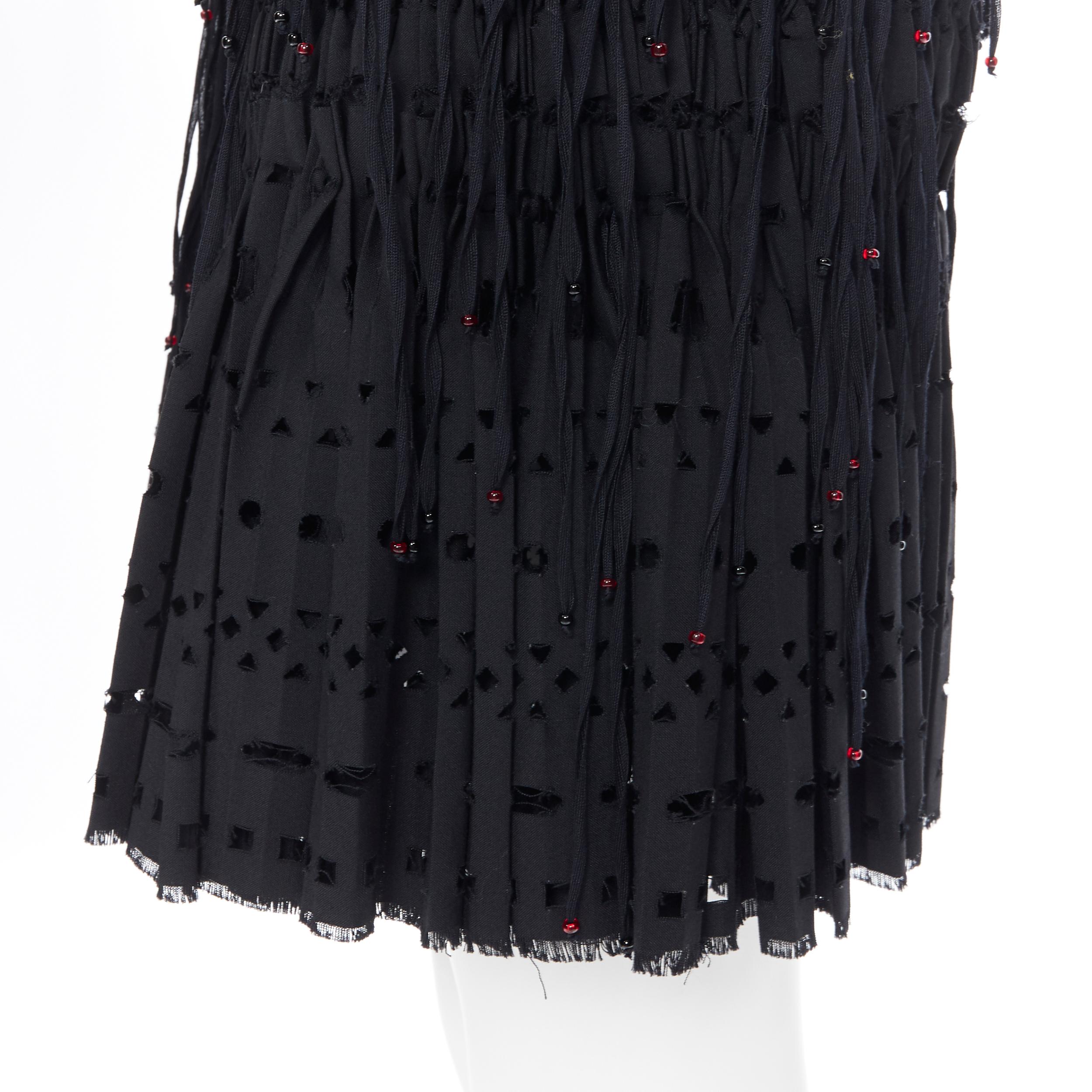 new ALAIA black geometric cut out pleated shirred red bead fringe skirt FR38 
Reference: TGAS/A00415 
Brand: Alaia 
Designer: Azzedine Alaia 
Material: Wool 
Color: Black 
Pattern: Geometric 
Closure: Zip 
Extra Detail: Red beaded fringe. Raw frayed