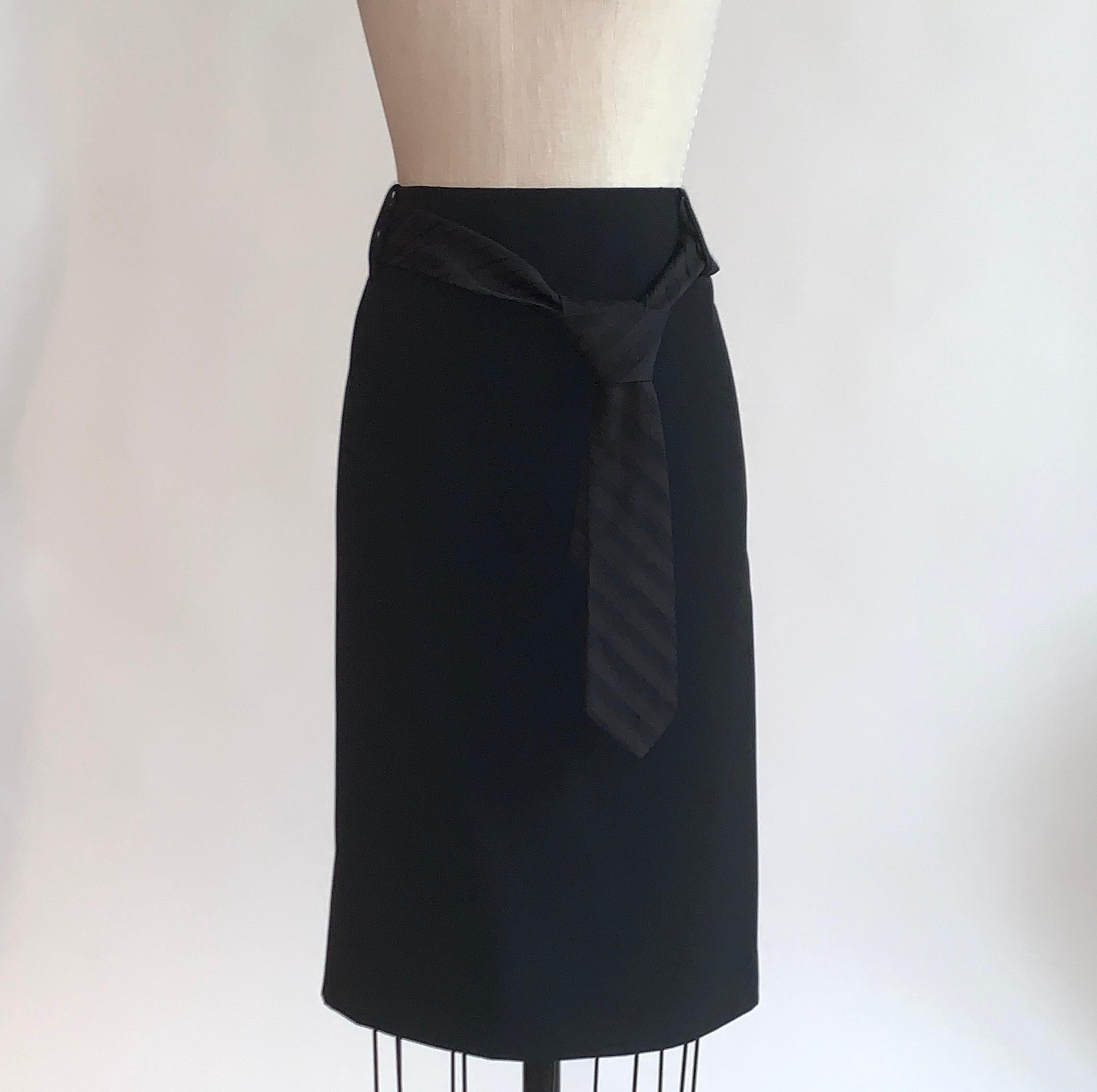 Alexander McQueen black pencil skirt with belt loops and a black on black striped belt that looks like a men's necktie. From the 2006 collection. Back zip and hook. Back slit. 

No content label (may have been a sample), feels like synthetic