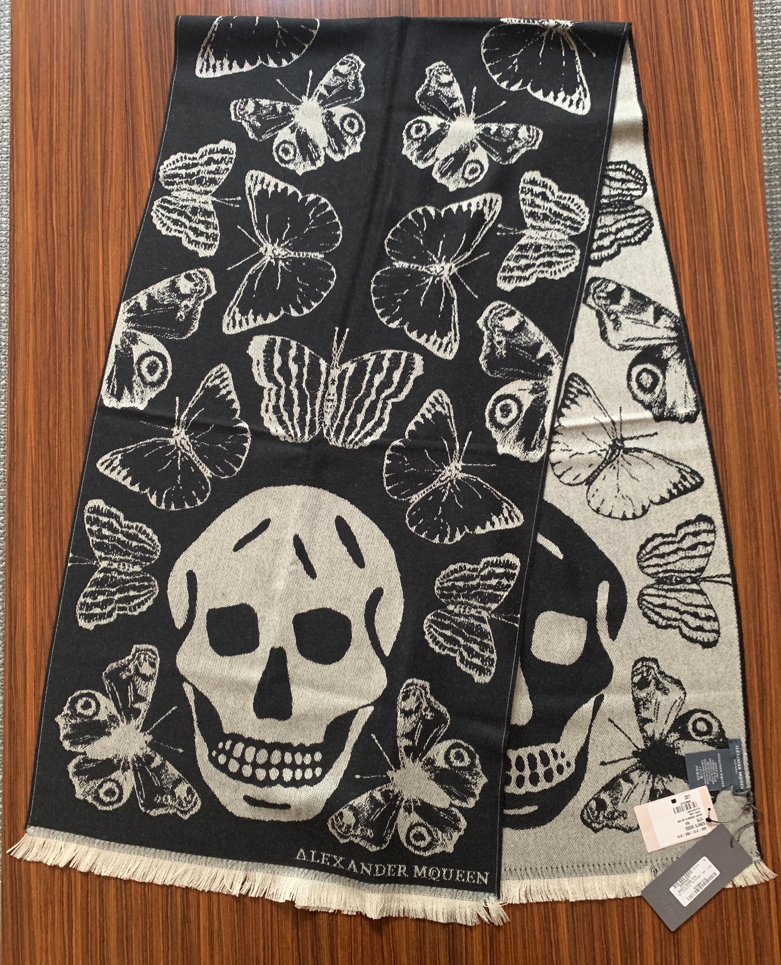 New Alexander McQueen large black scarf featuring butterflies or moths throughout and a large skull at each end. Super soft wool. Light fringe at ends. Signed Alexander McQueen at one bottom corner.

Purchased directly from McQueen store.

100%